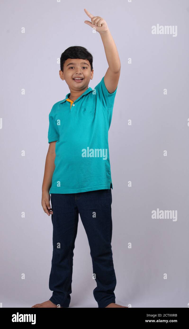 Smiling young boy with his index finger raised. Isolated over white Stock Photo