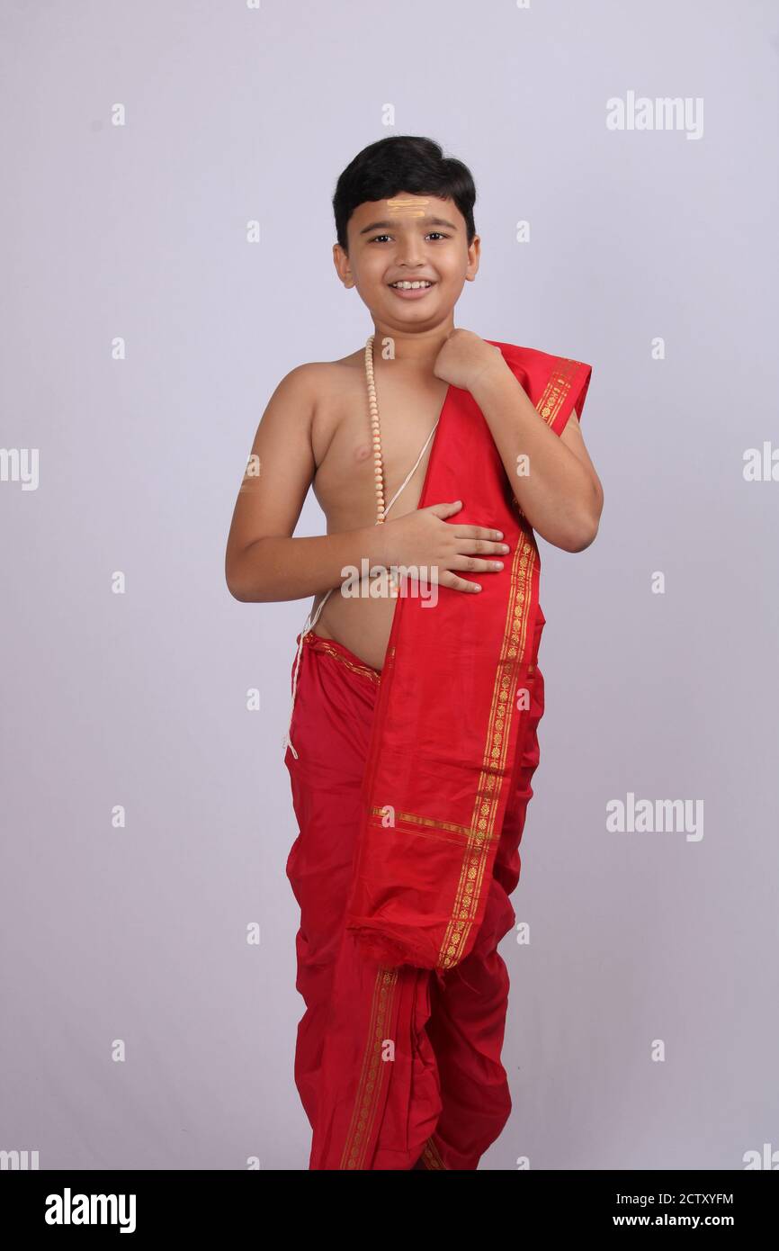 cute Indian boy in ethnic wear sovla and uparna - dhoti and stole. holding his stole. Stock Photo