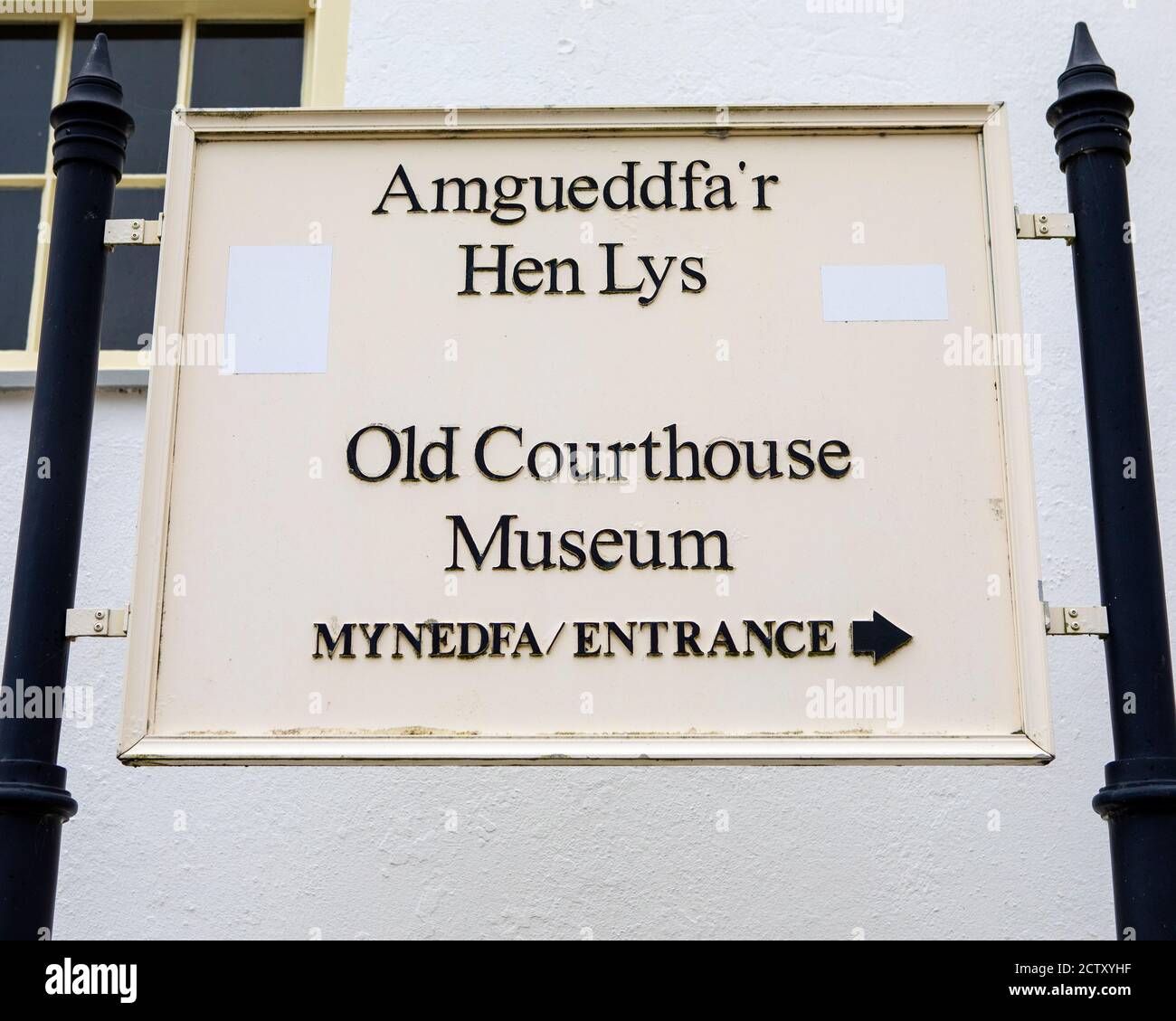 A sign in both the Welsh and English languages, at the entrance to the Old Courthouse Museum, in the town of Beaumaris on the Isle of Angelsey in Wale Stock Photo