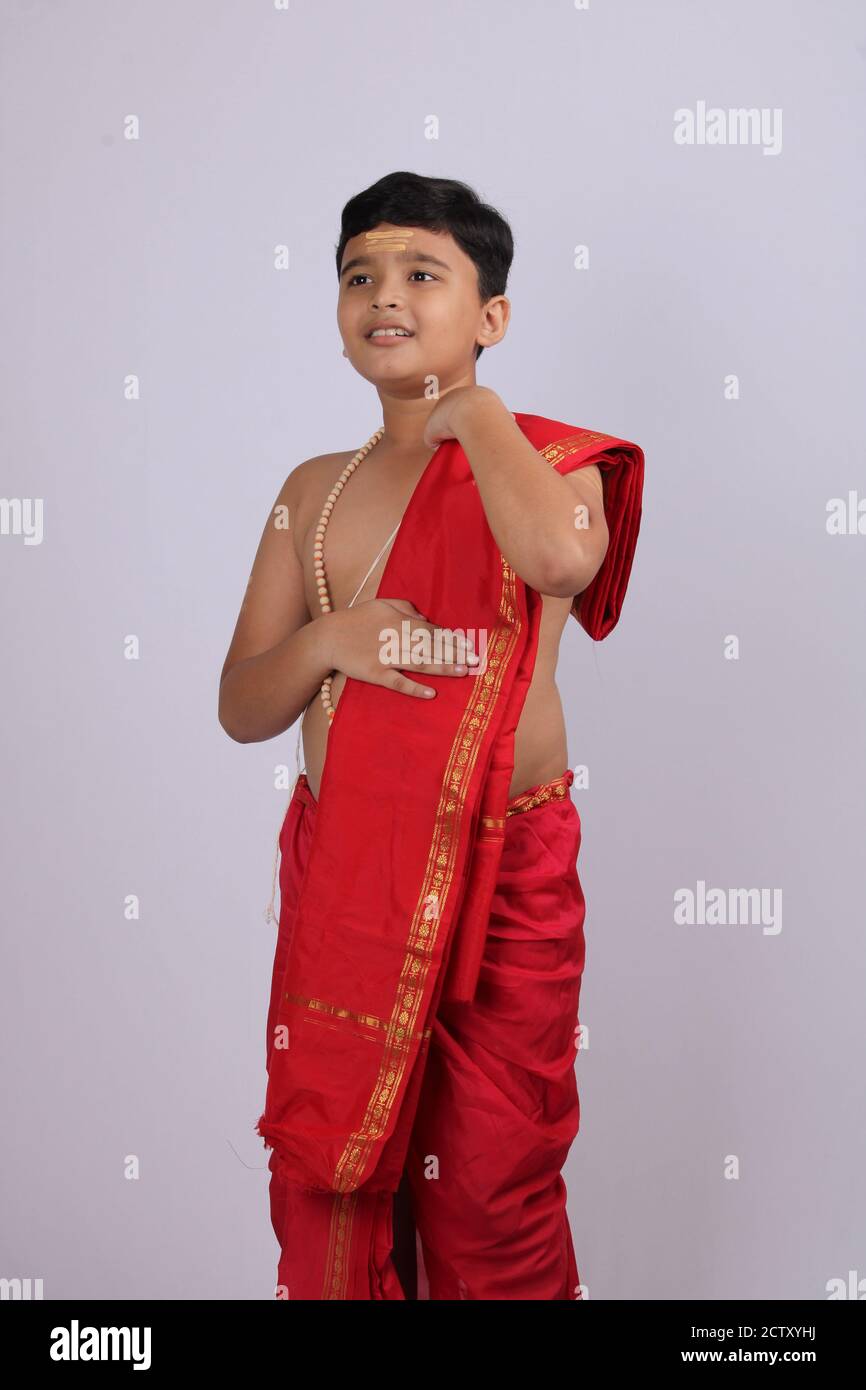 cute Indian boy in ethnic wear sovla and uparna - dhoti and stole. holding his stole. Stock Photo