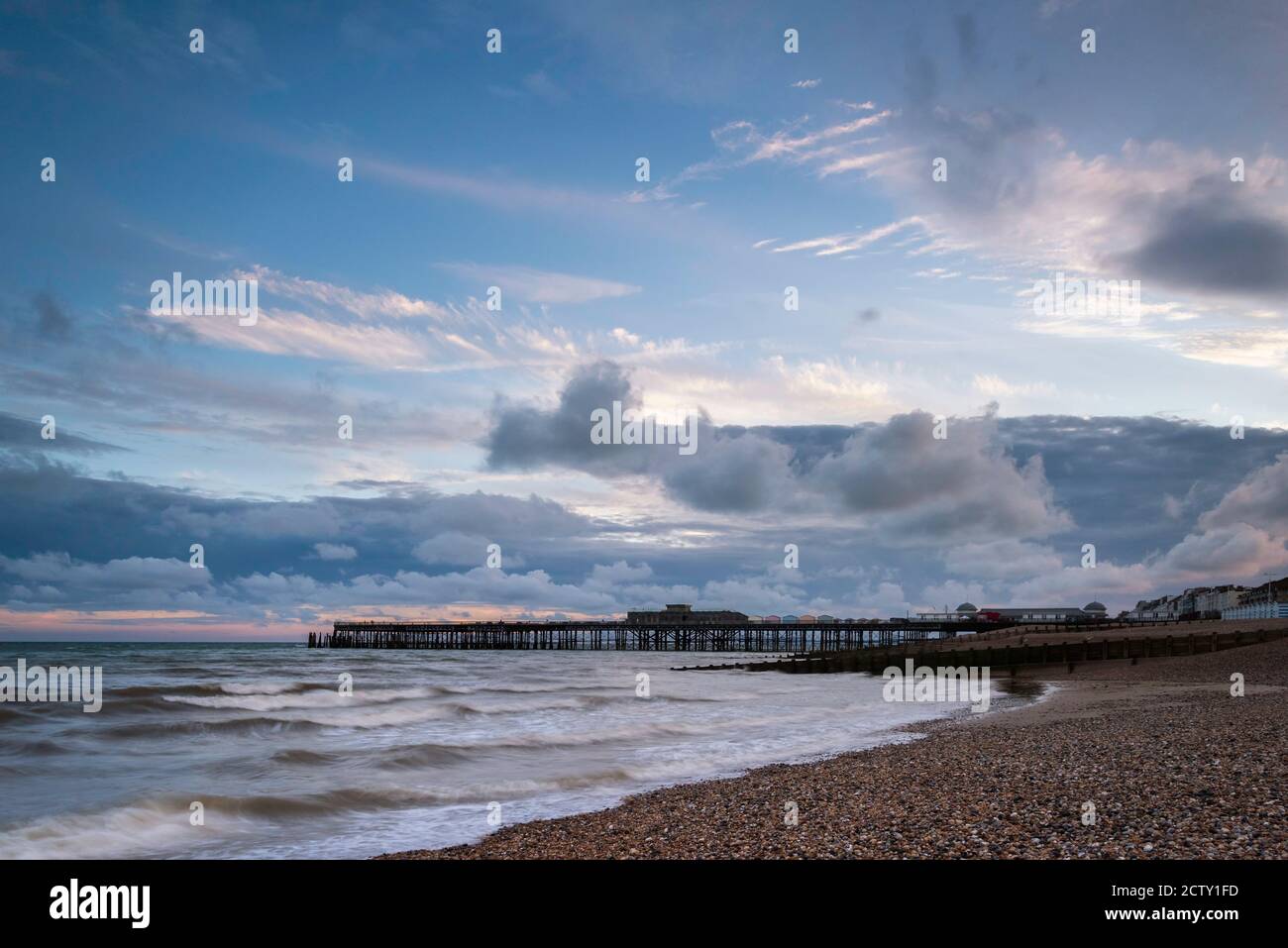 Sunset behind Hastings Pier viewed along the beach, East Sussex, England Stock Photo