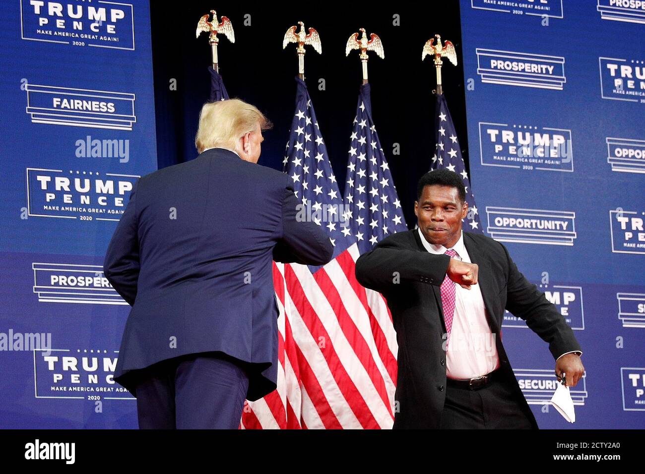 us-president-donald-trump-elbow-bumps-retired-nfl-football-player-herschel-walker-before-delivering-remarks-on-black-economic-empowerment-during-an-event-at-the-cobb-galleria-centre-in-atlanta-georgia-us-september-25-2020-reuterstom-brenner-2CTY2A0.jpg
