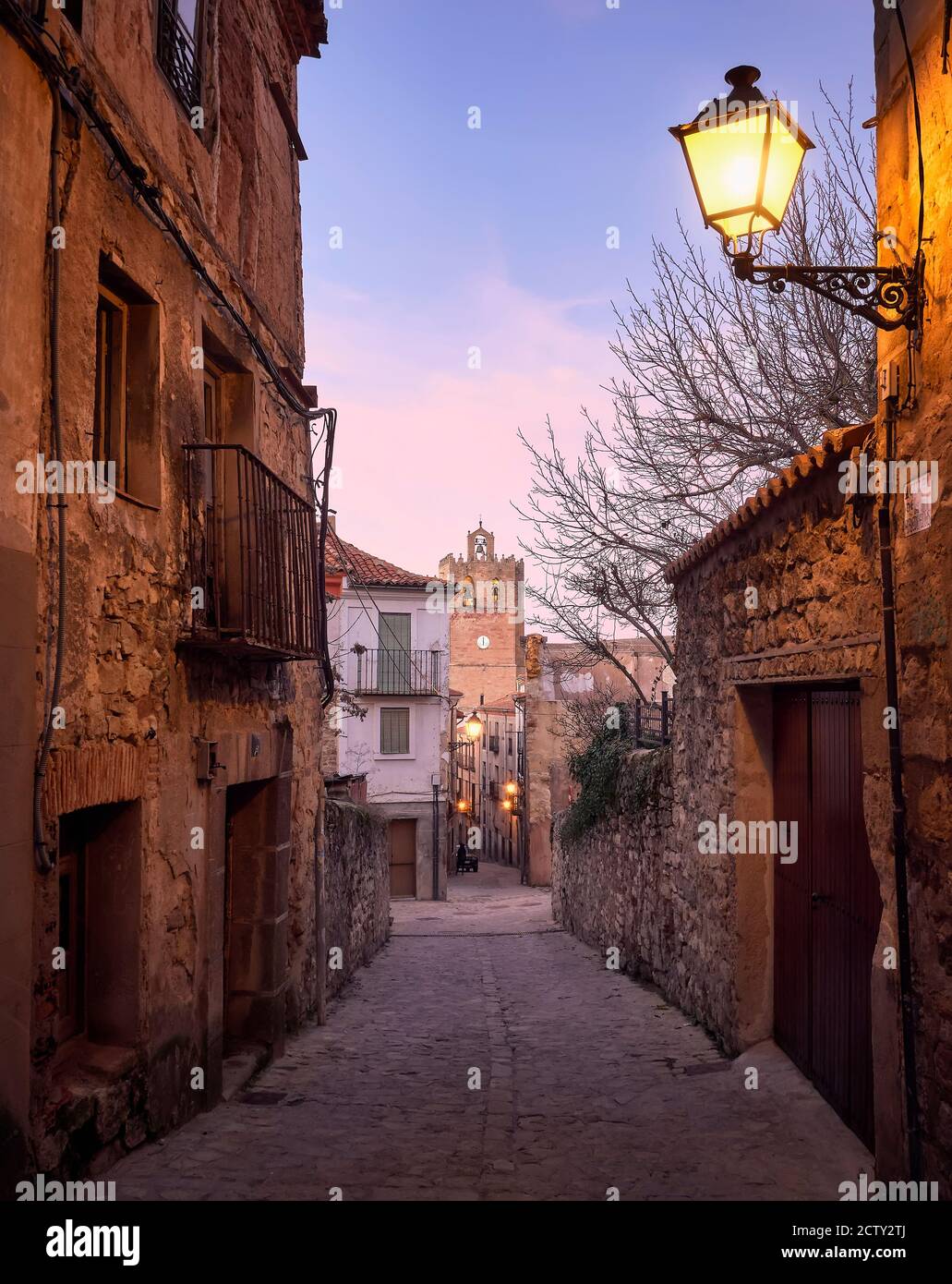 Historic architecture of the streets and tower of the Romanesque cathedral of the city of Siguenza, Guadalajara, Spain, at sunset Stock Photo
