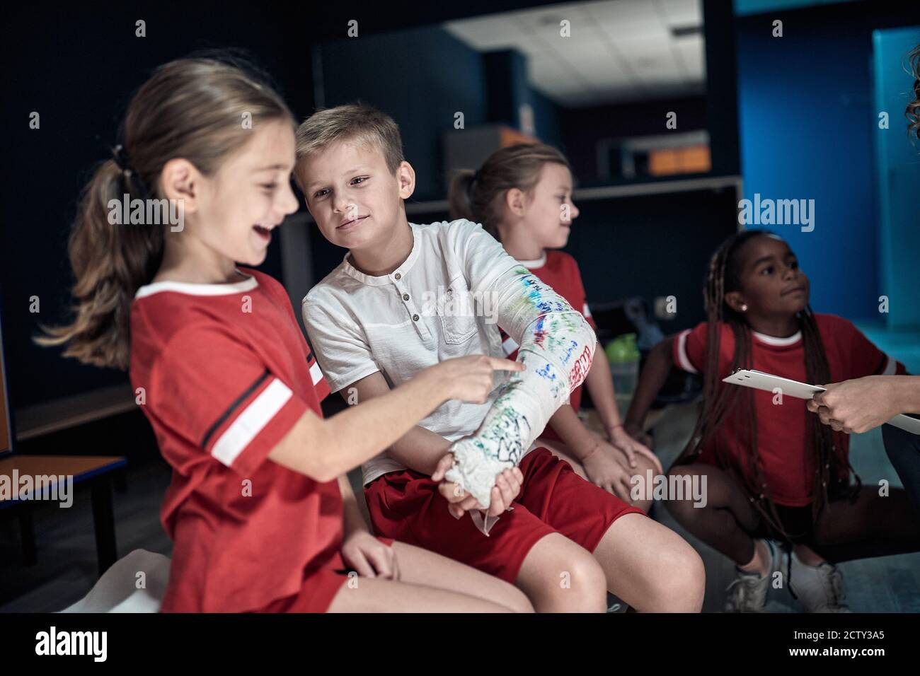 Injured a little soccer player and his team mates in a locker room Stock Photo