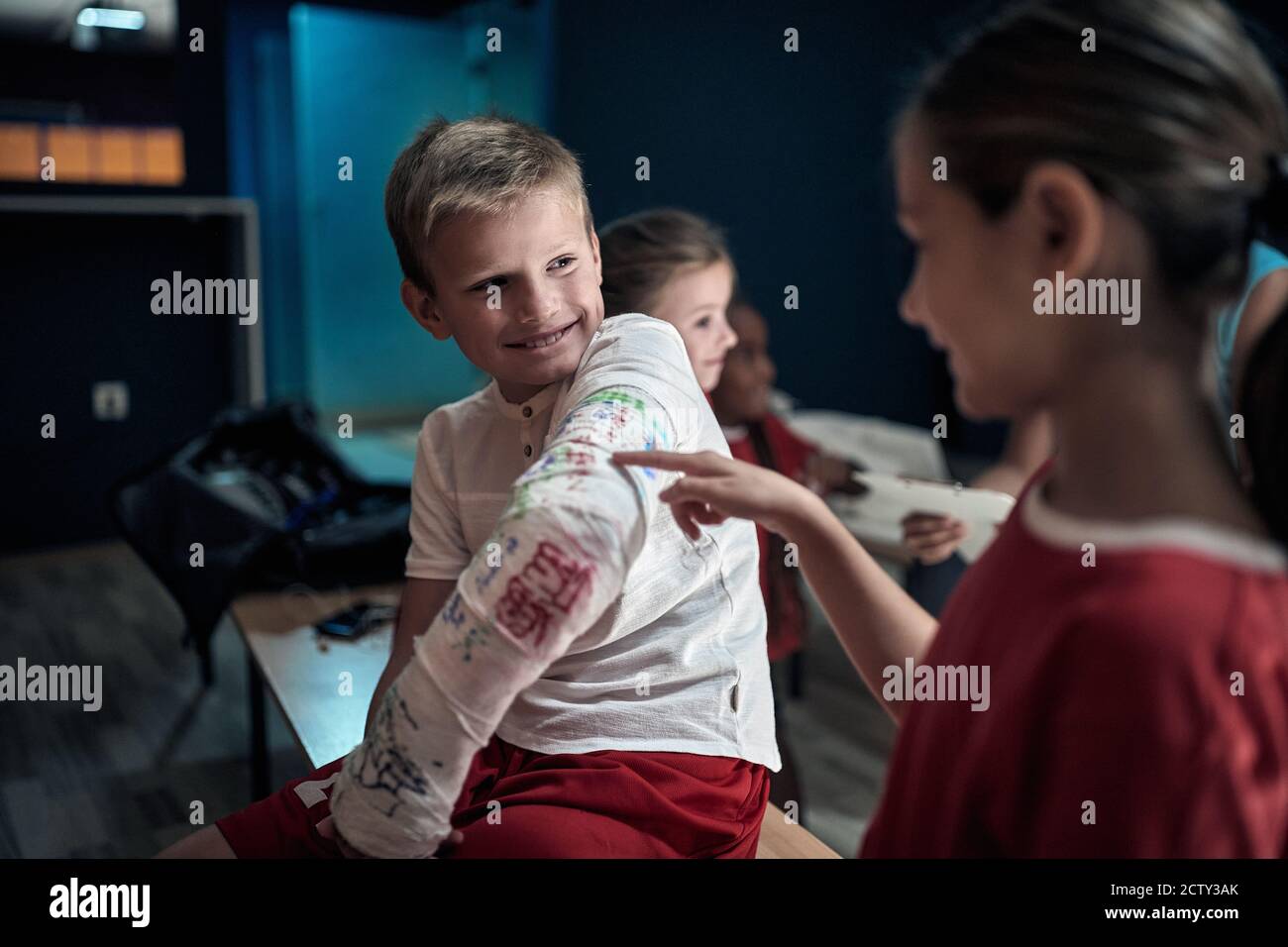 Injured a little soccer player showing his broken arm to team mates in a locker room Stock Photo