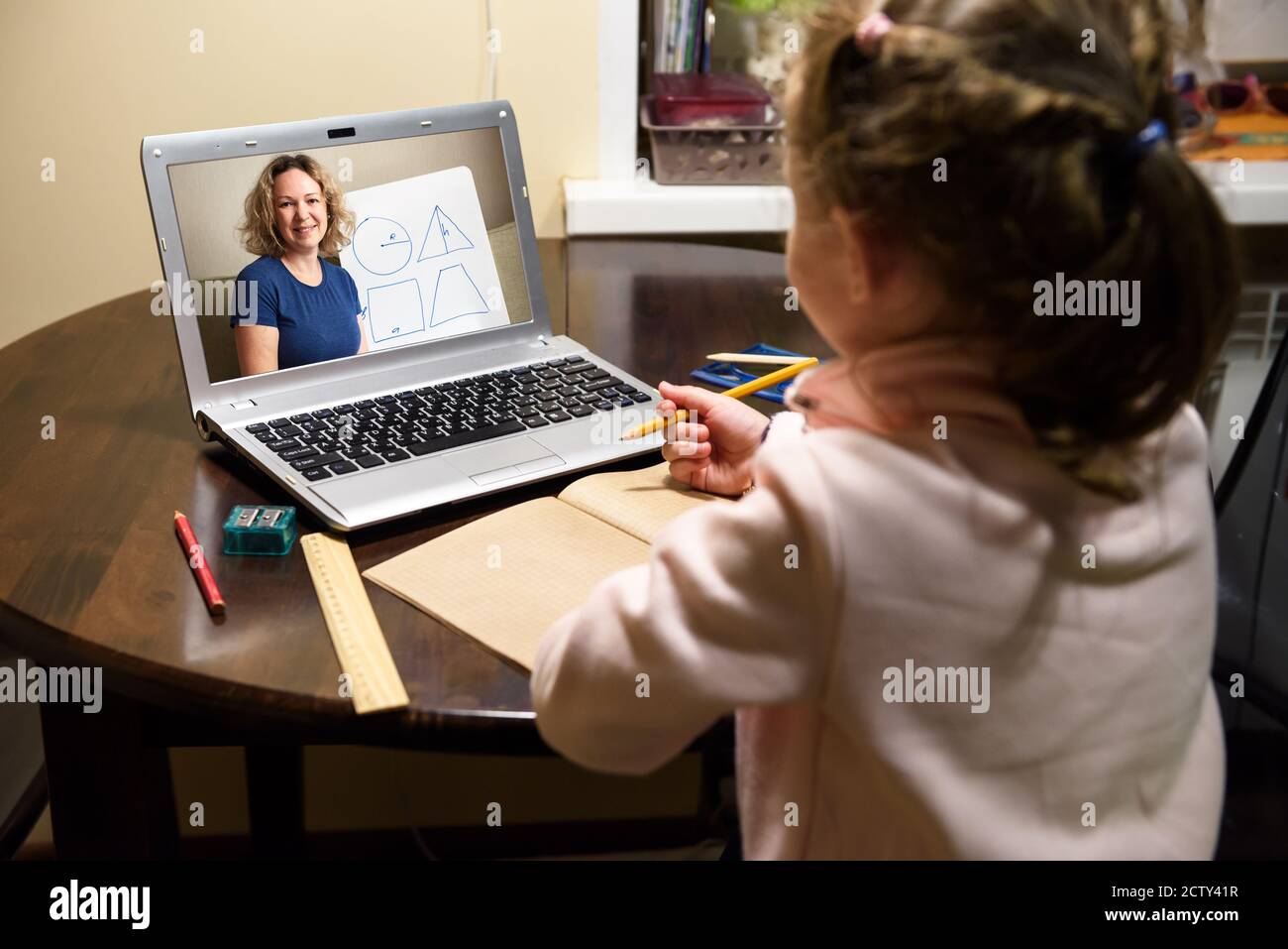 Online home education, tutor teaches preschool child during quarantine due to coronavirus. Kid learning with teacher by laptop. Concept of virtual dis Stock Photo