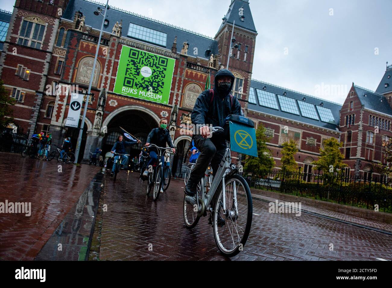 An activist riding his bike with the XR logo on it during the global climate day.Climate activists gathered at the Museumplein with their bikes to ride around the center of the city during the global climate action day, to demand climate action. The activists ended at the same place. The action was organized by Fridays for Future Nederland and Extinction Rebellion Amsterdam. Stock Photo