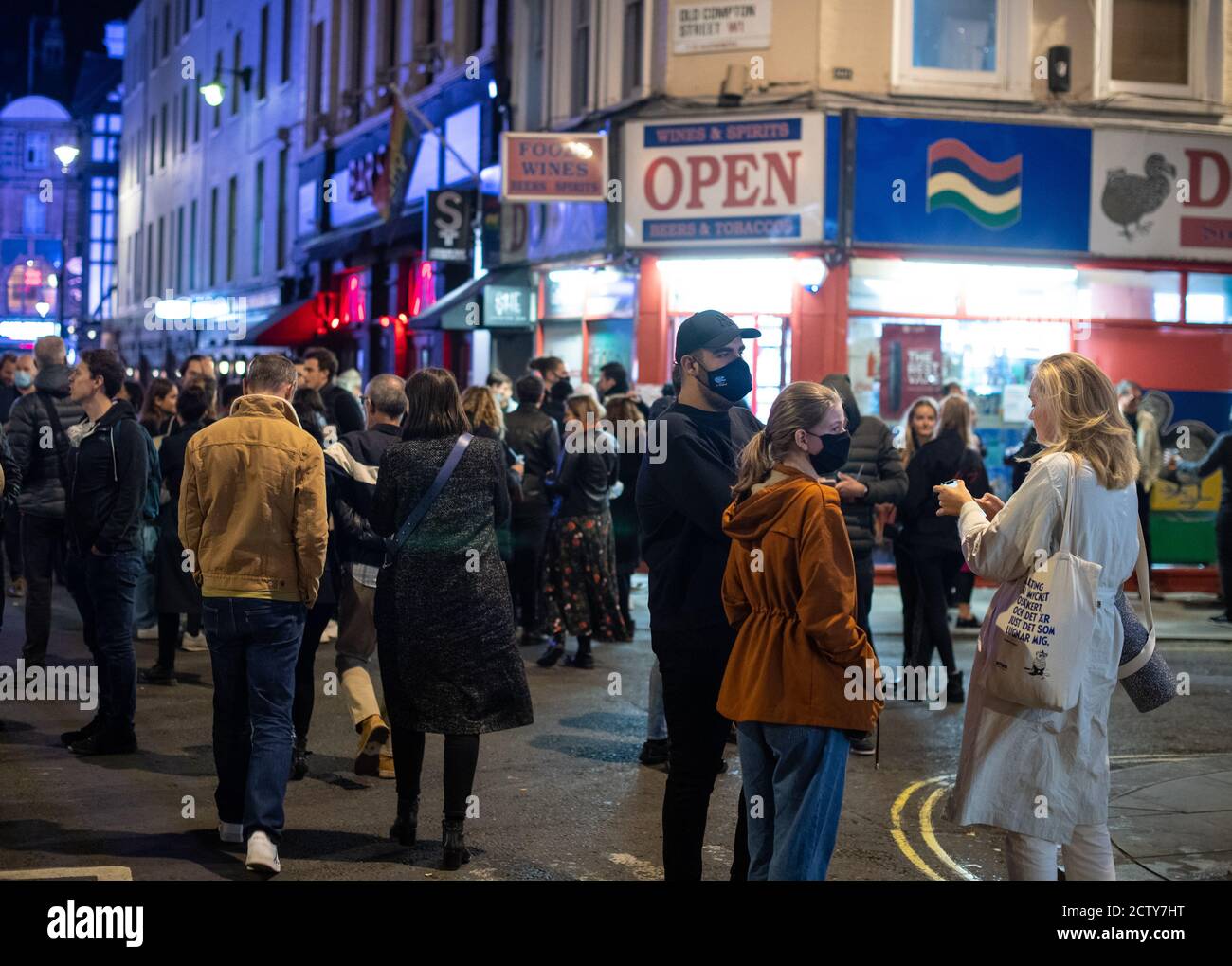 People leave bars and restaturants at closing time in Soho, London, the day after pubs and restaurants were subject to a 10pm curfew to combat the rise in coronavirus cases in England. Stock Photo