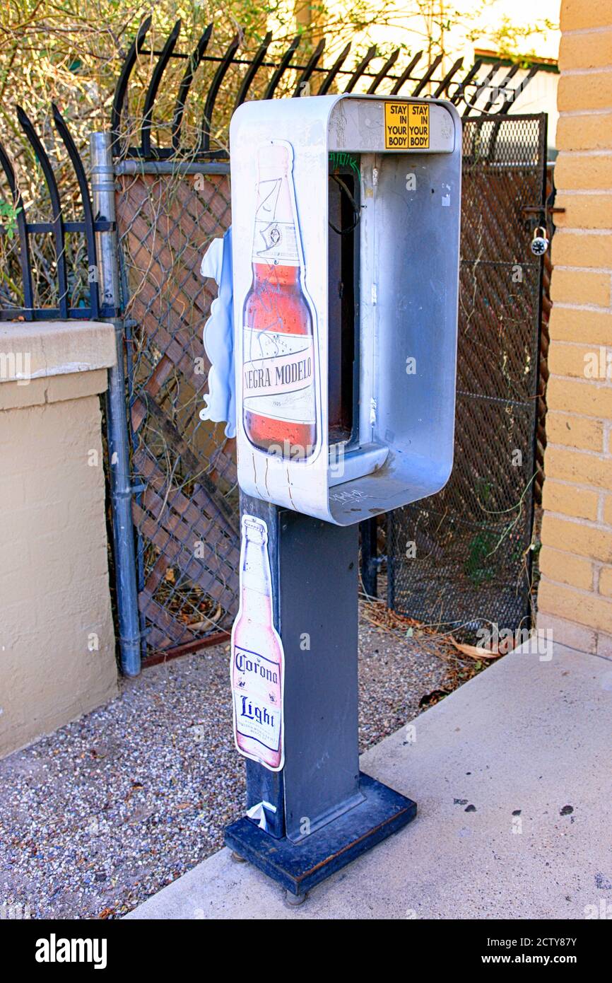 Disused public telephone kiosk outside a liquor store in downtown