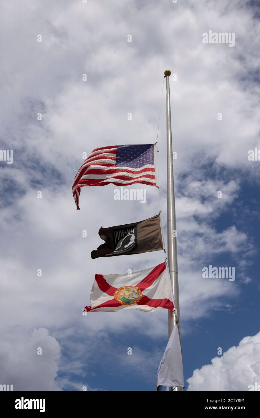 Flags flying at half mast including the IA POW flag and the Florida State flag Stock Photo