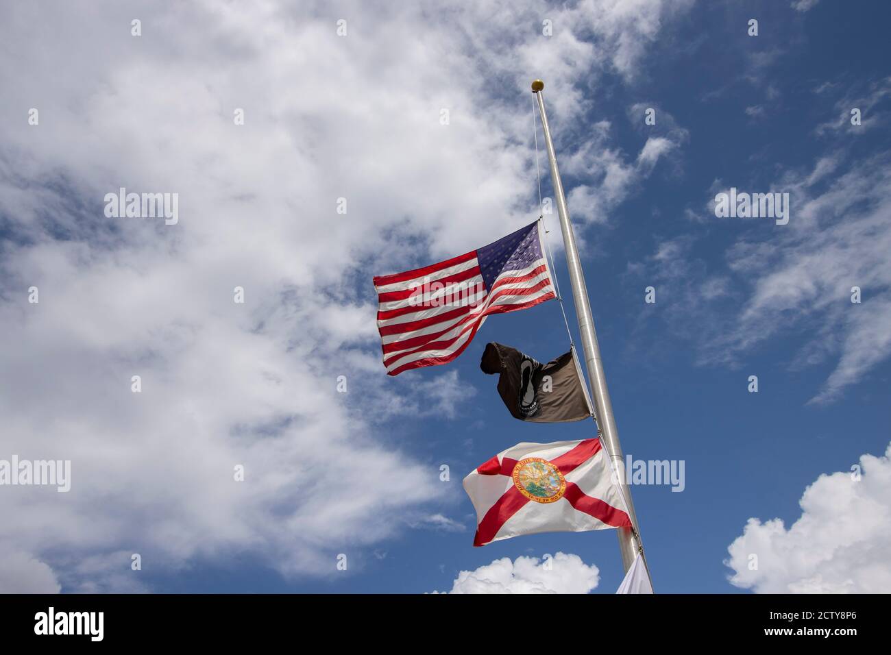 Flags flying at half mast including the IA POW flag and the Florida State flag Stock Photo