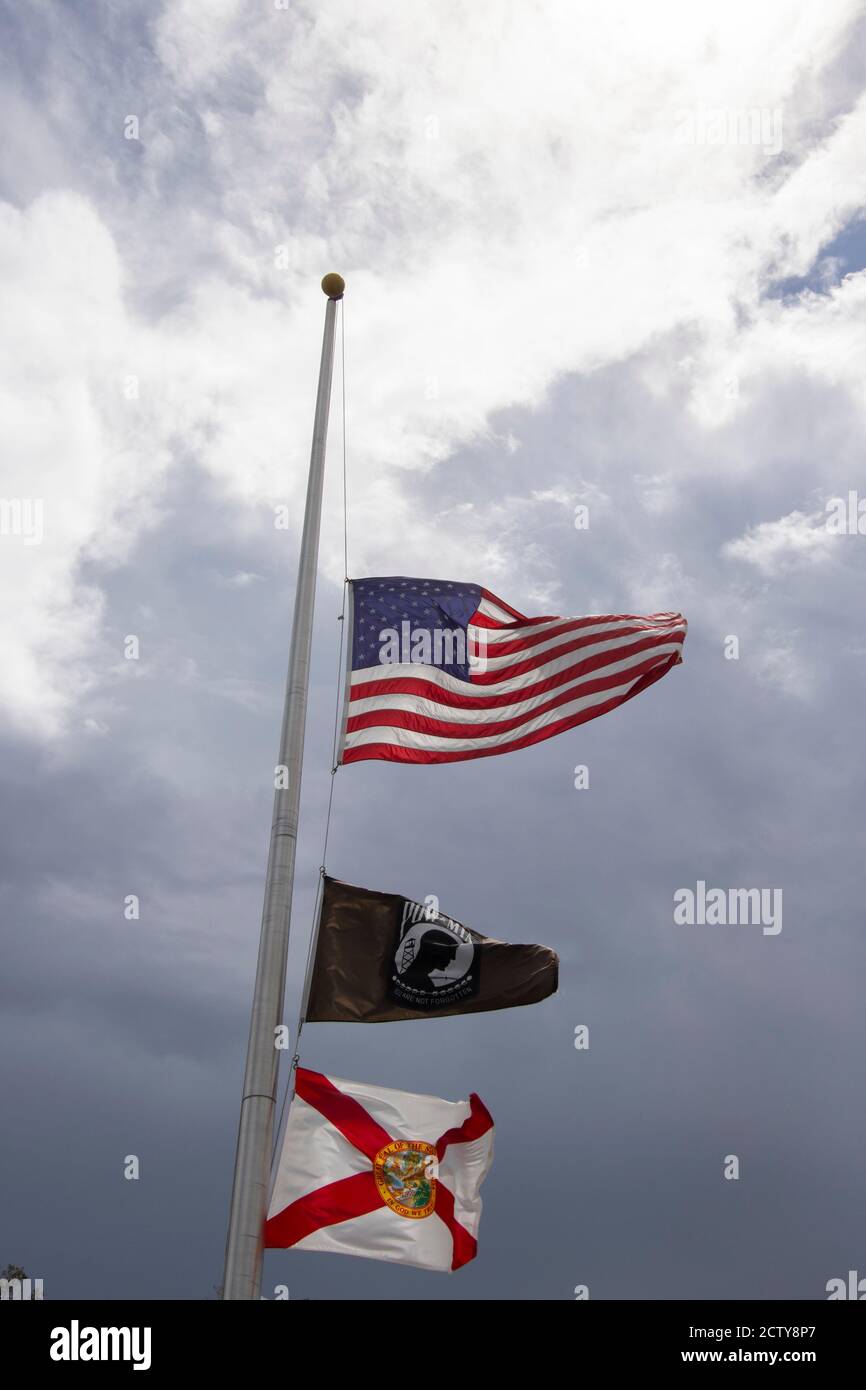 Flags flying at half mast including the IA POW flag and the Florida State flag Stock Photo