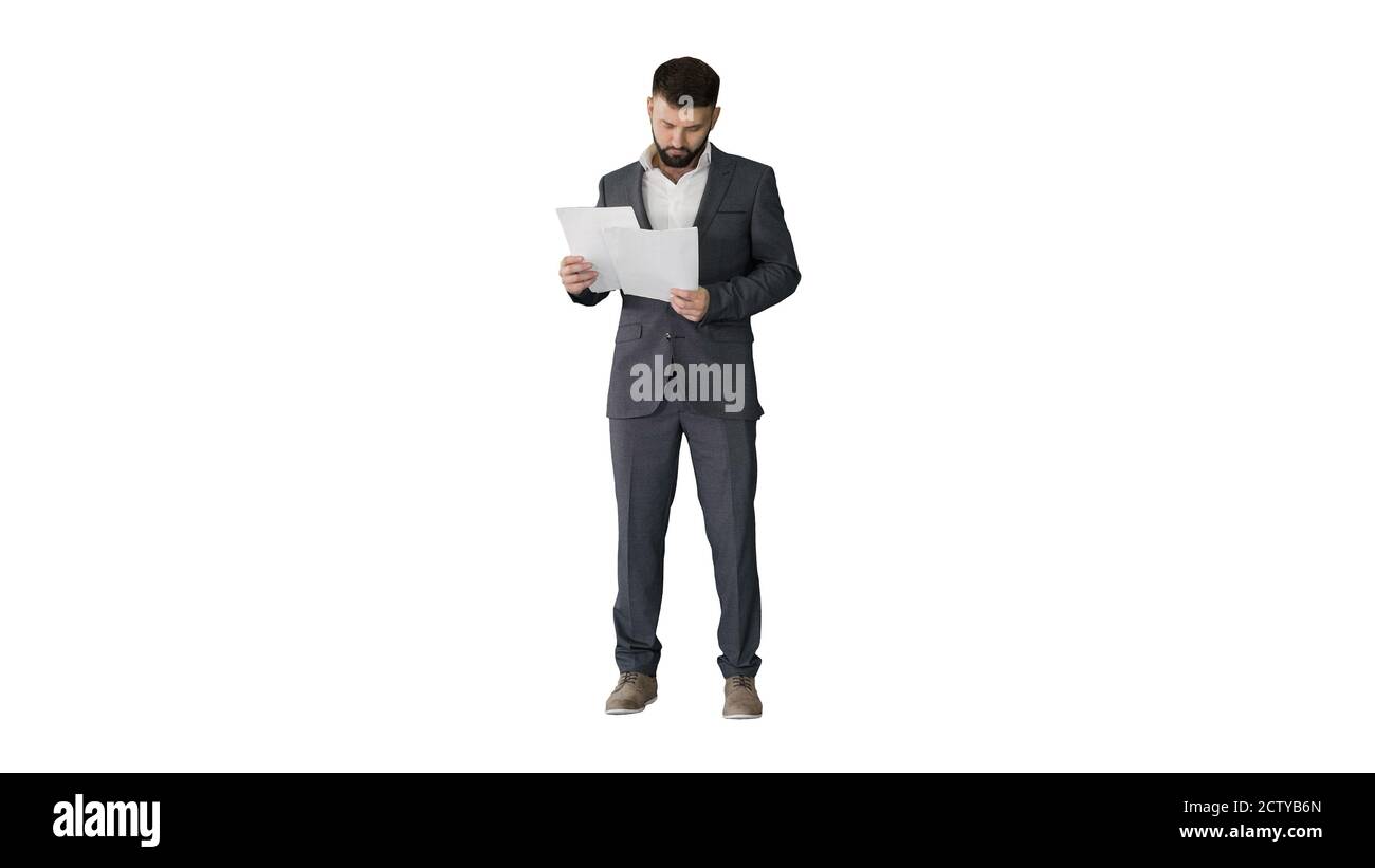 Businessman standing and reading papers seriously on white backg Stock ...