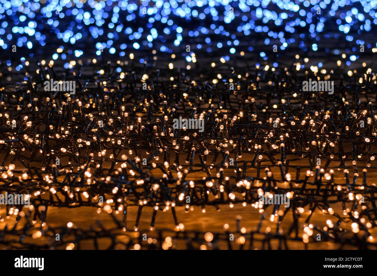 Blue and yellow lights Christmas garlands. Abstract background. Selective focus. Stock Photo