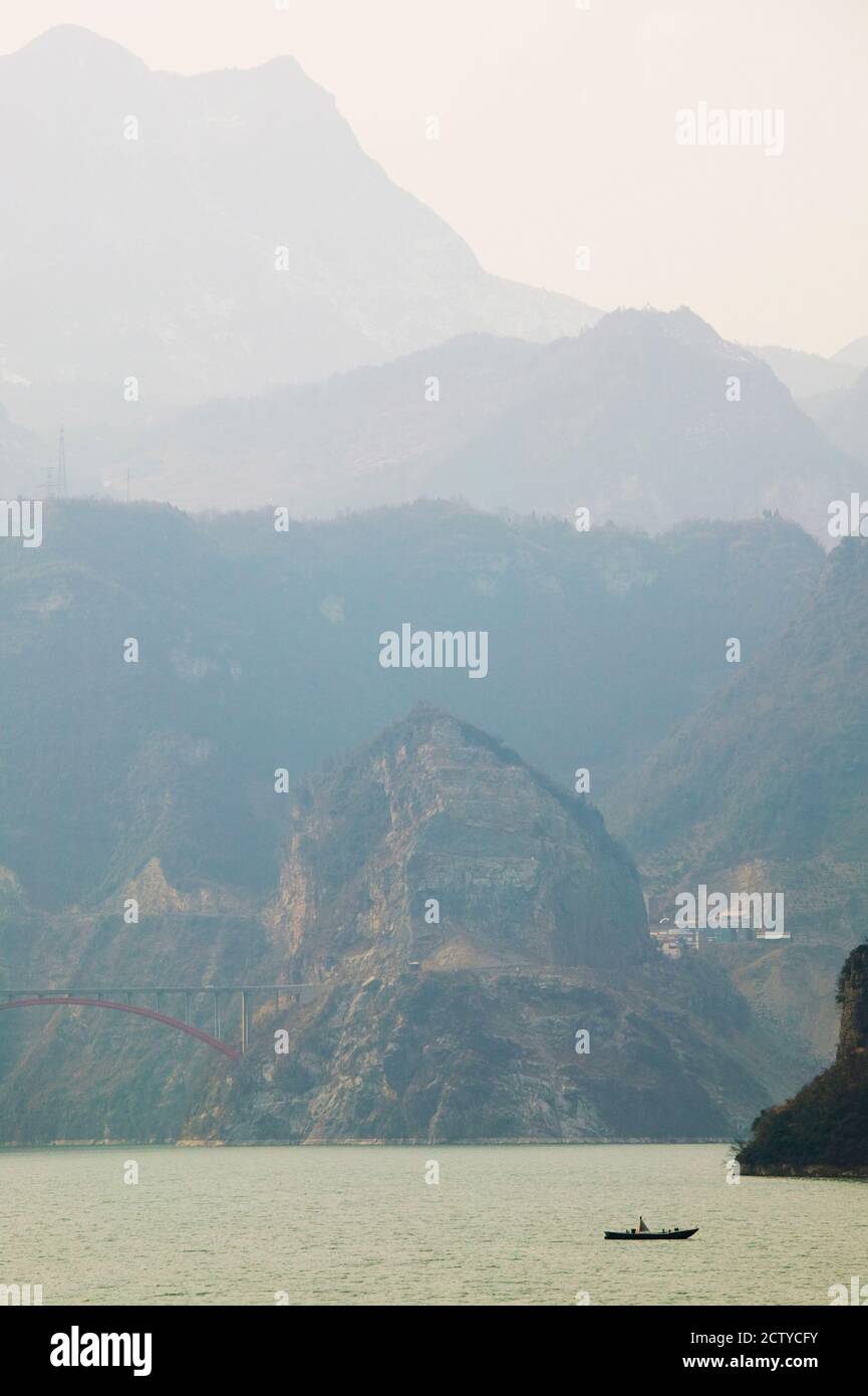 Boat in the river with foggy mountains in the background, Xiling Gorge, Yangtze River, Hubei Province, China Stock Photo