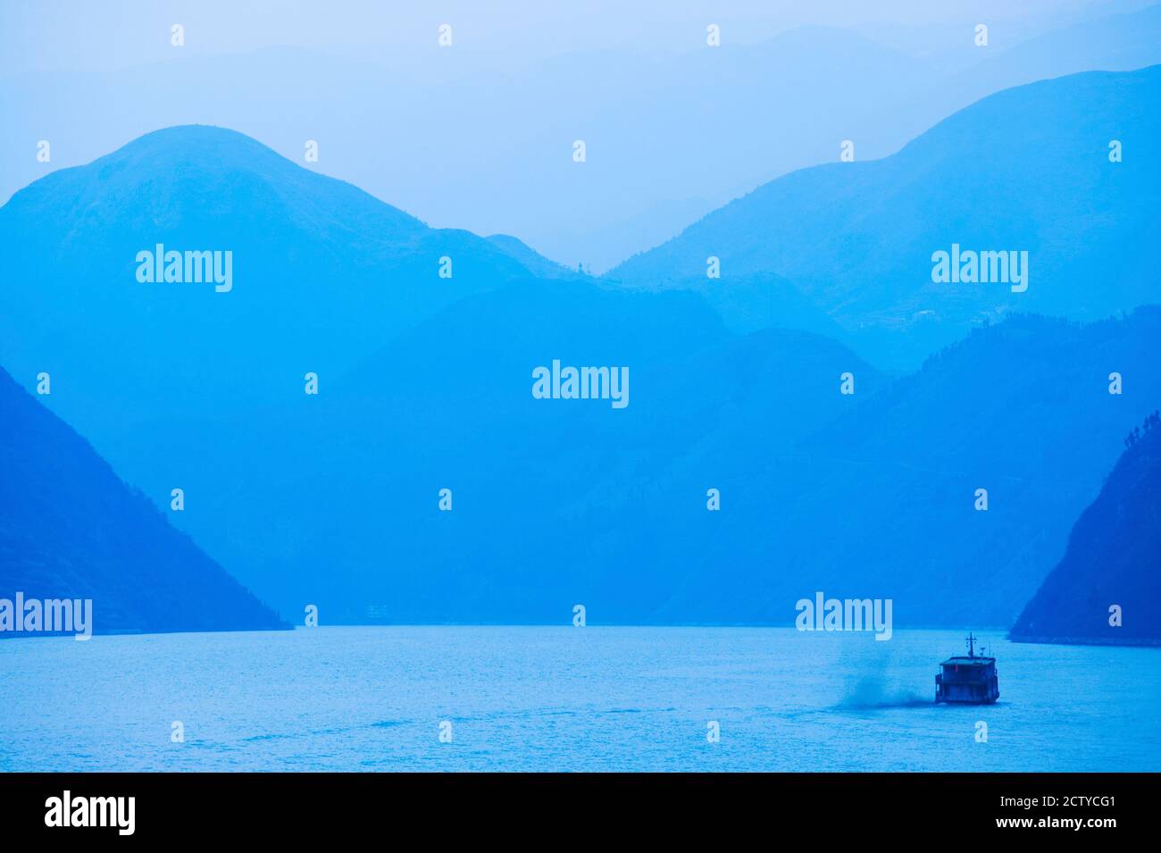 Boat in the river with foggy mountains in the background, Wu Gorge, Yangtze River, Hubei Province, China Stock Photo