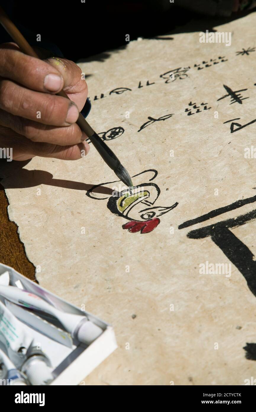 Chinese calligrapher painting calligraphy on a paper at the Dongba Place, Old Town, Lijiang, Yunnan Province, China Stock Photo