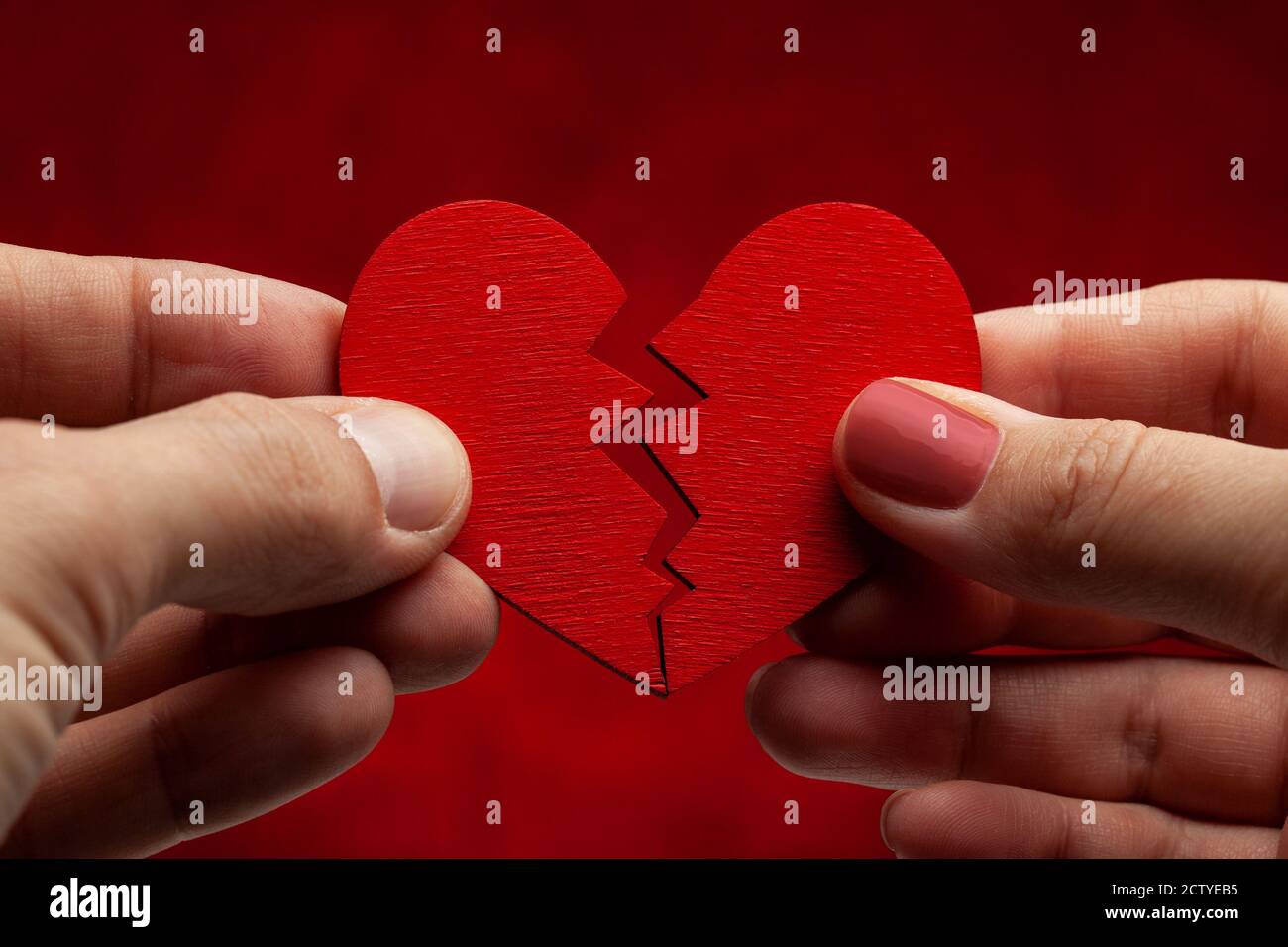 Man and woman break off relationship. Broken heart. Crack in the red heart, Breaking the relationship. Stock Photo