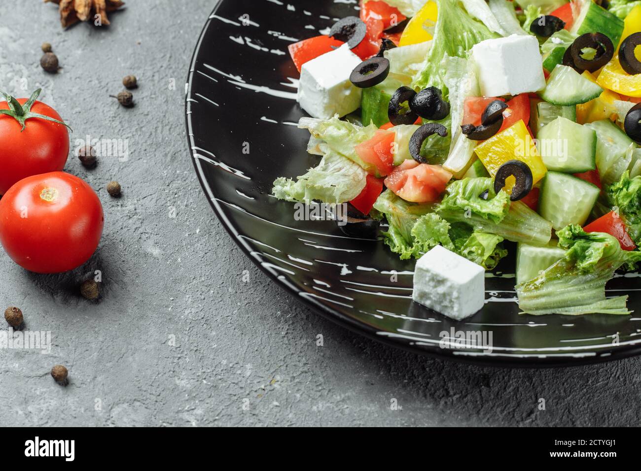 Greek Salad with Cucumeber, Kalamata Olives, Feta Cheese, Juicy Cherry Tomatoes and Fresh Basil. Concept for a tasty and healthy vegetarian meal Stock Photo