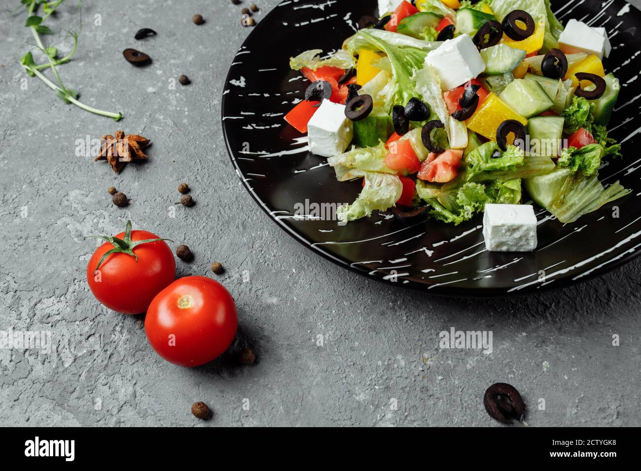 Greek Salad with Cucumeber, Kalamata Olives, Feta Cheese, Juicy Cherry Tomatoes and Fresh Basil. Concept for a tasty and healthy vegetarian meal Stock Photo