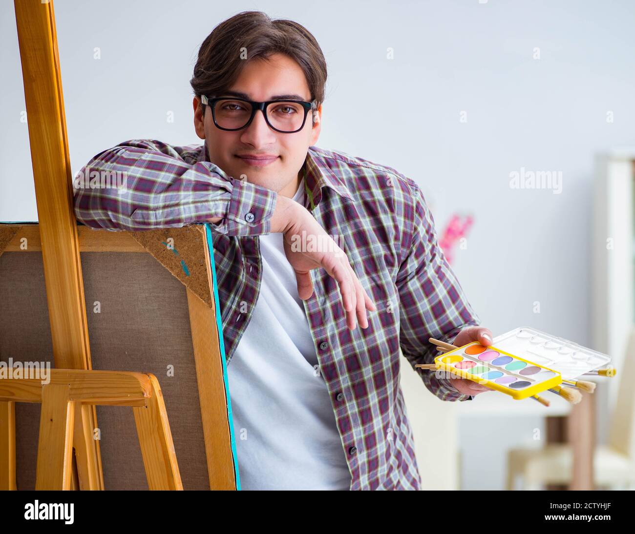 The young male artist drawing pictures in bright studio Stock Photo - Alamy