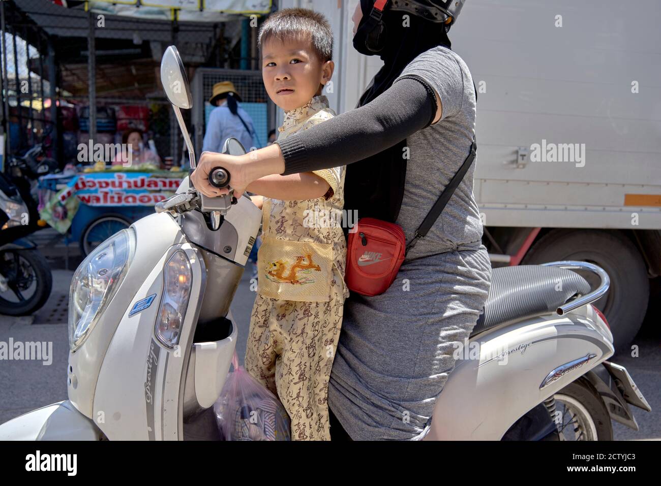 Child motorcycle. Mother with child passenger riding a motorbike in ...