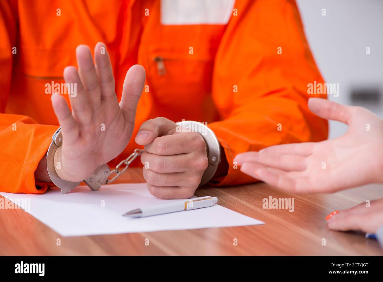 Young man meeting with advocate in pretrial detention Stock Photo