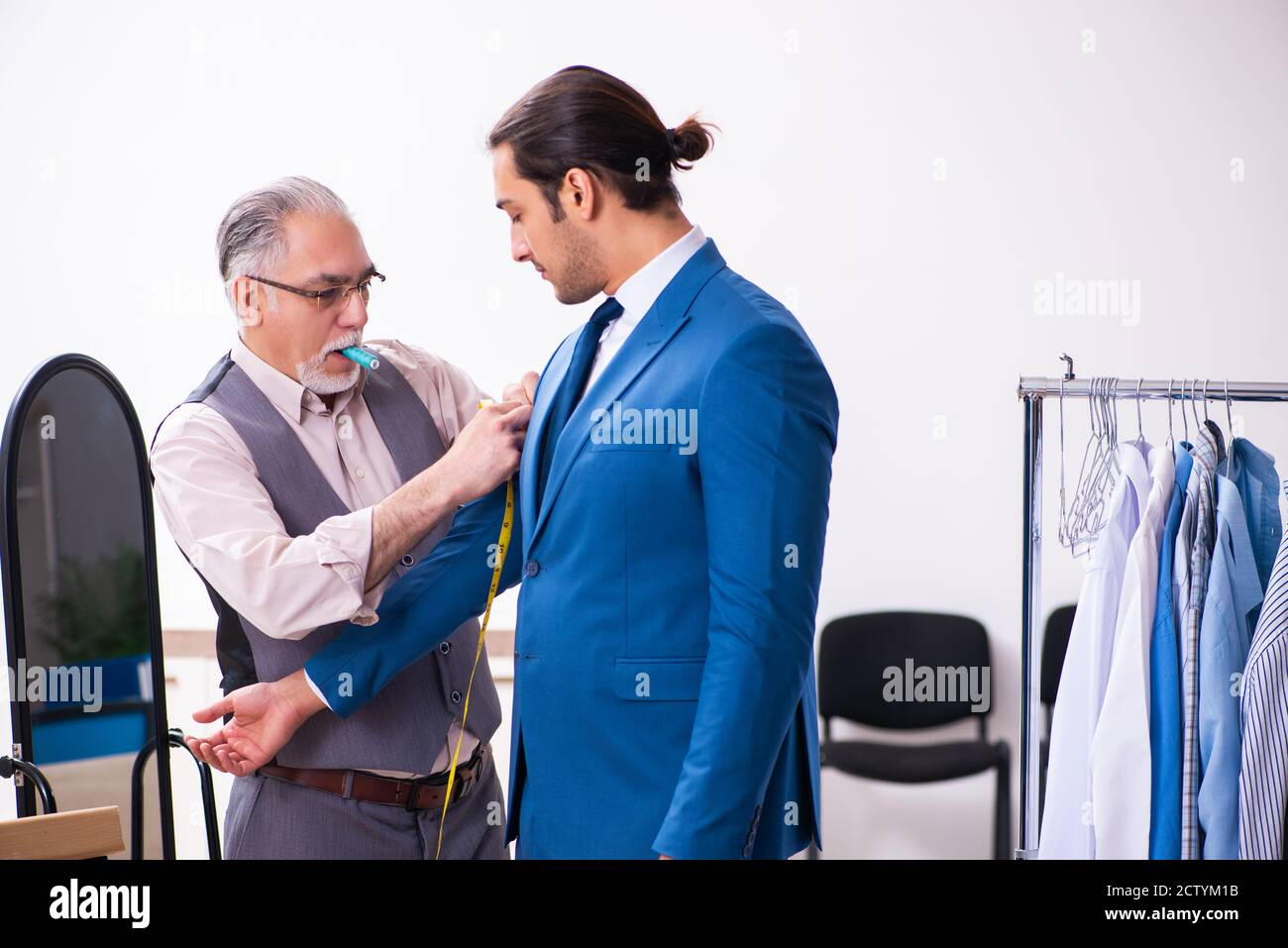 Young businessman visiting old tailor Stock Photo
