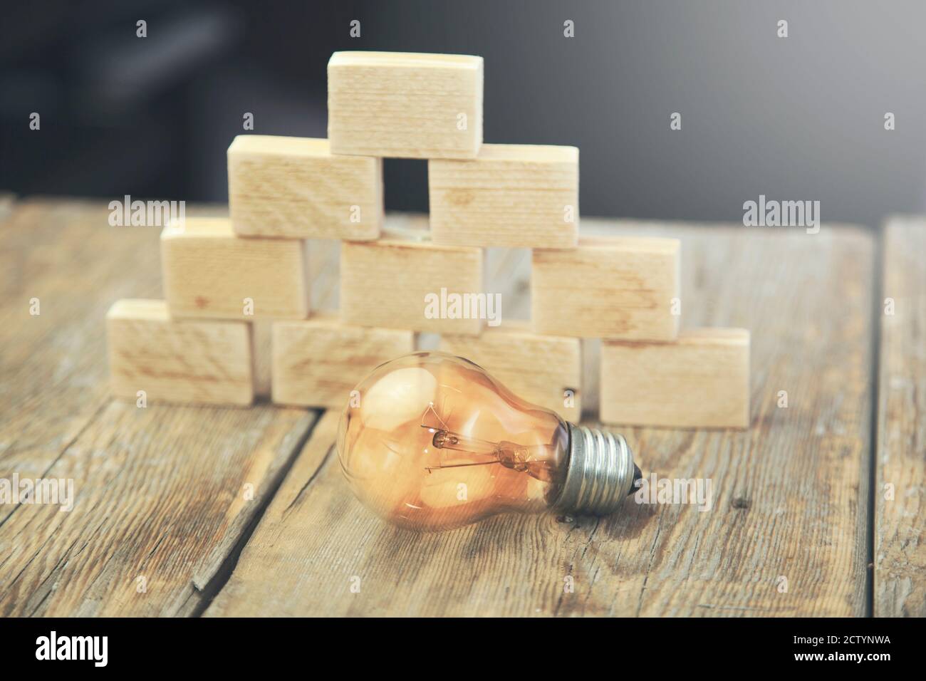 Light bulb and Blocks of wood isolated on wooden background Stock Photo ...