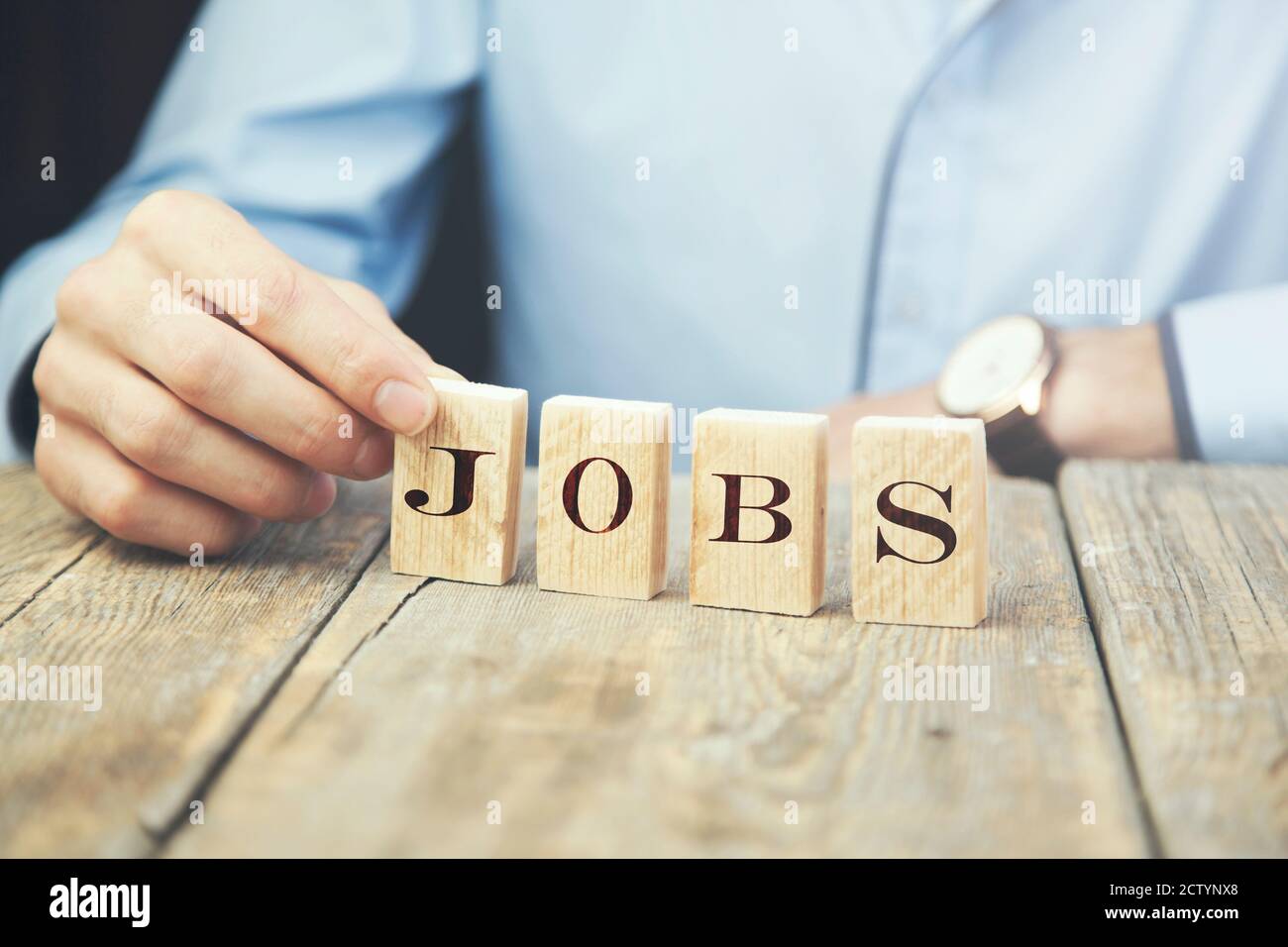 business man holding wooden cubes reading -Jobs Stock Photo