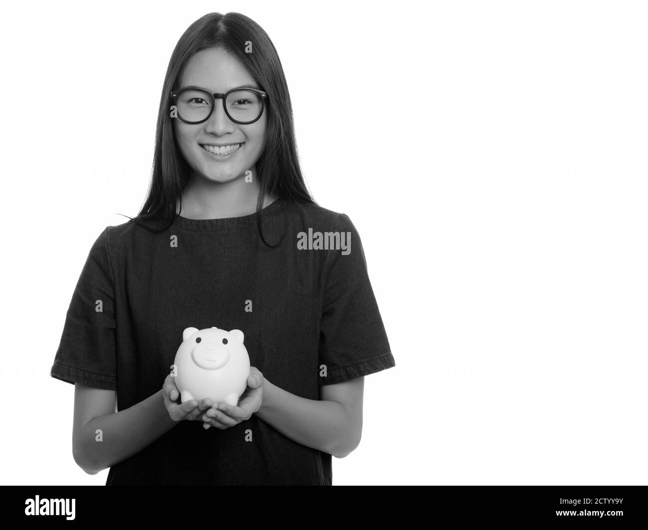 Young happy Asian teenage girl smiling and holding piggy bank Stock ...
