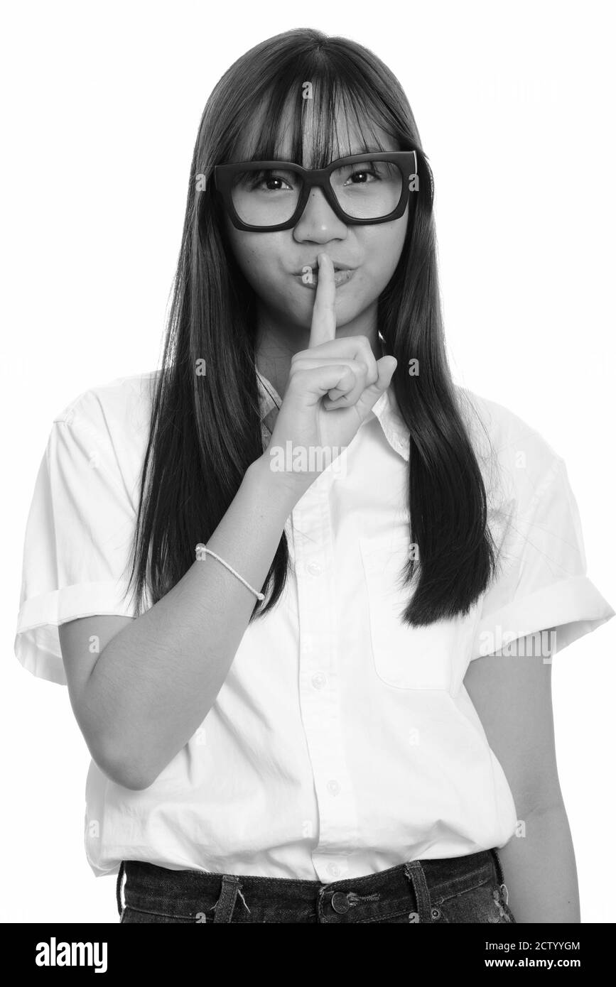 Young cute Asian teenage girl with finger on lips Stock Photo