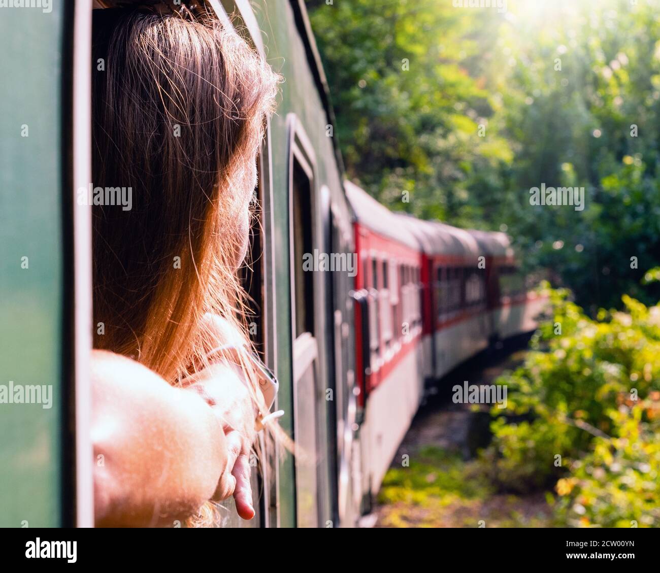 Woman looking out the window of the old train. Bulgarian mountains, Alpine railway in the Balkans Stock Photo