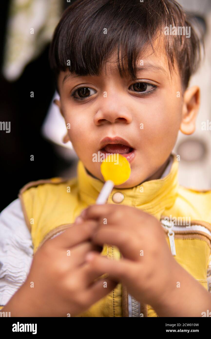 Cut little boy eating lollipop candy and having fun in outdoor at day time.00. Stock Photo