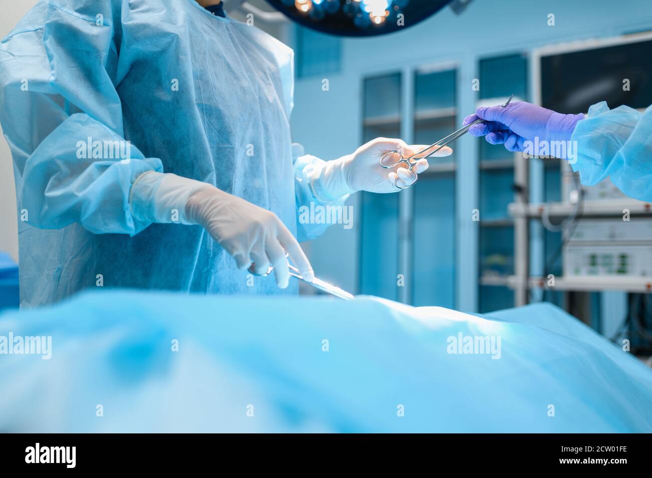 Female surgeon and assistant performs operation Stock Photo