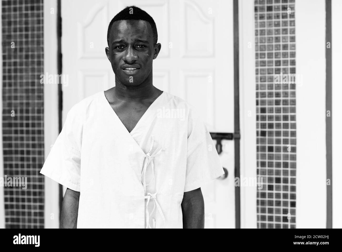 Studio shot of young black African man patient in the front door at home Stock Photo