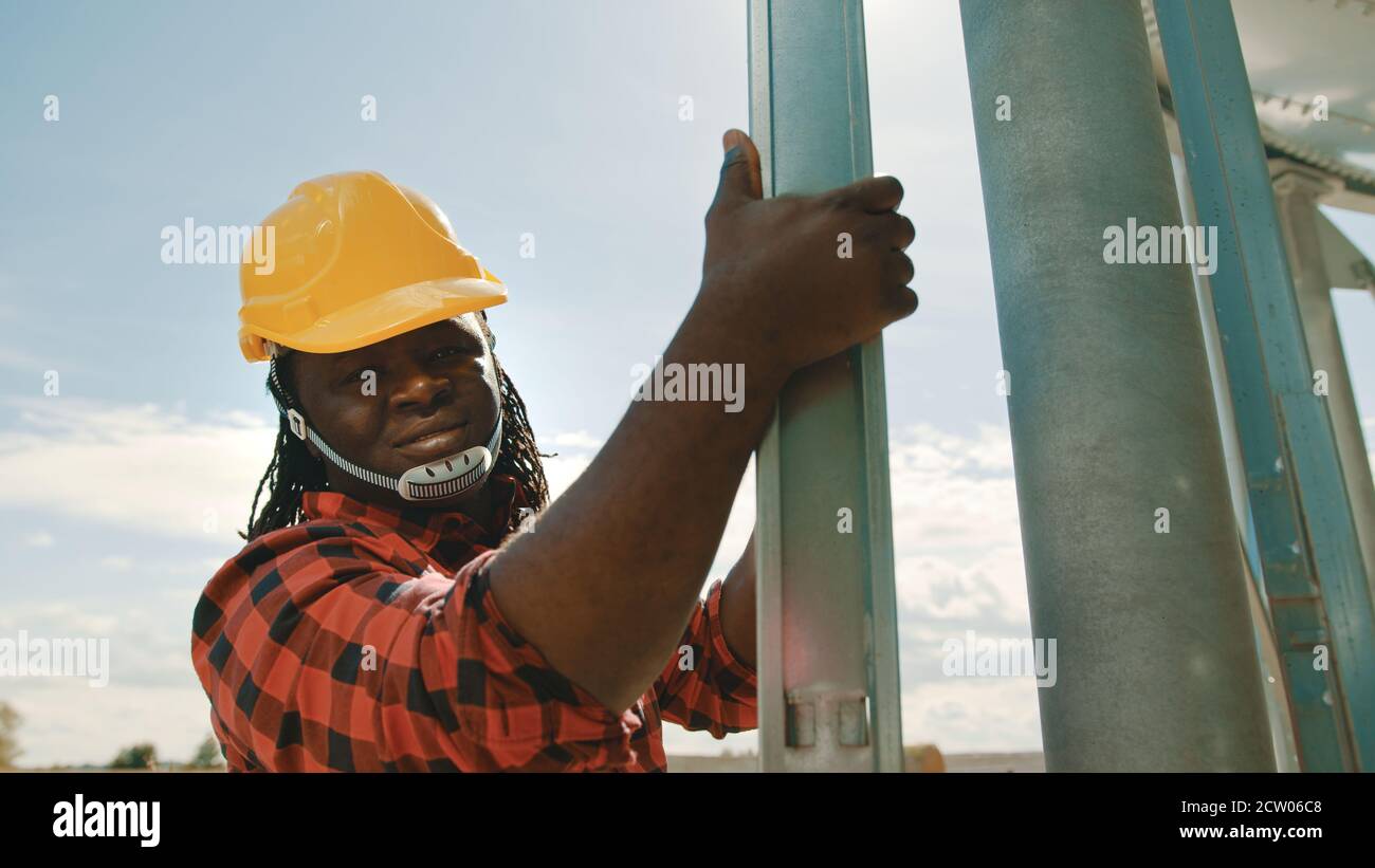 African black man engineer climbing on the leders of the silio system . High quality photo Stock Photo