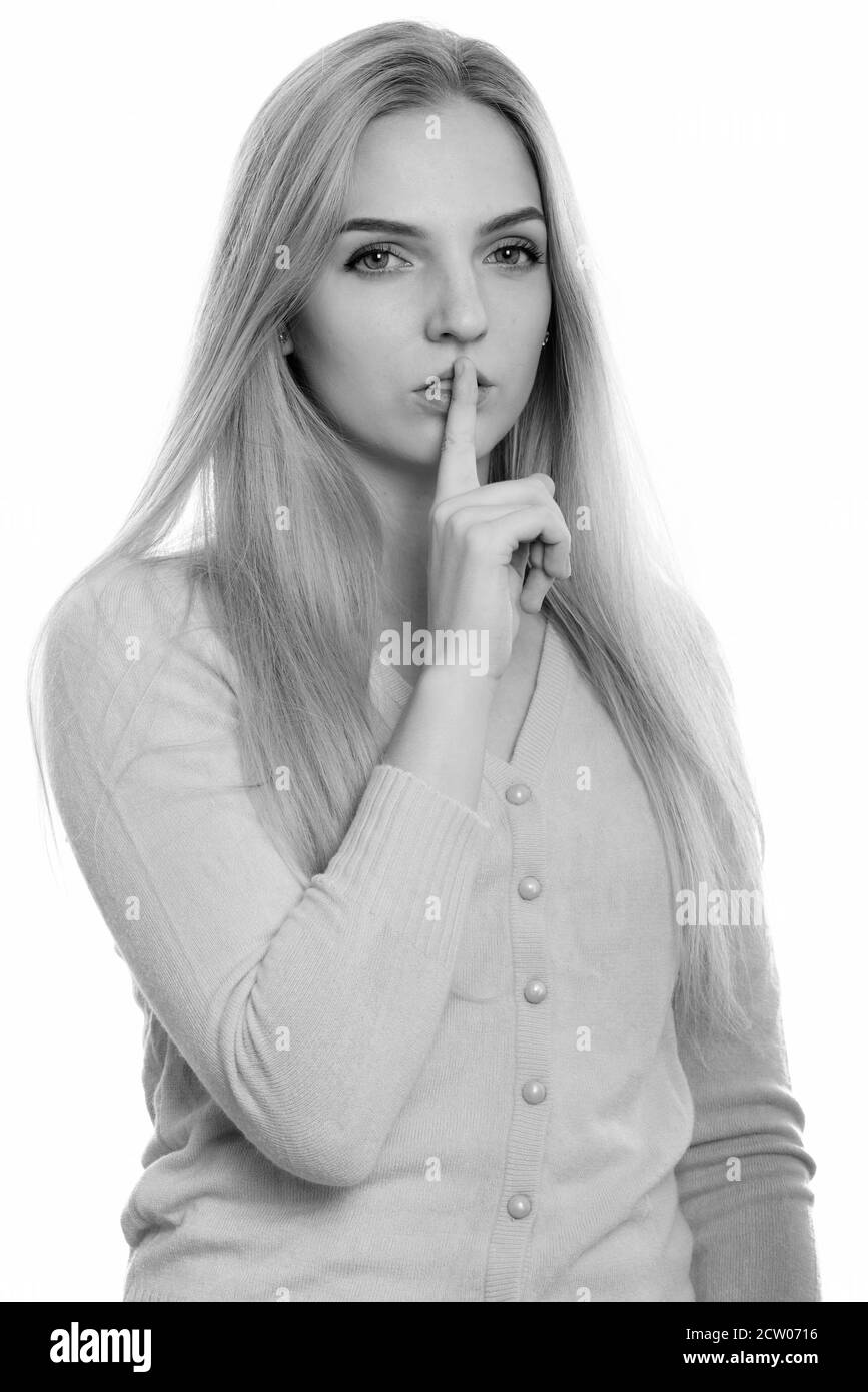 Studio shot of young beautiful teenage girl with finger on lips Stock Photo