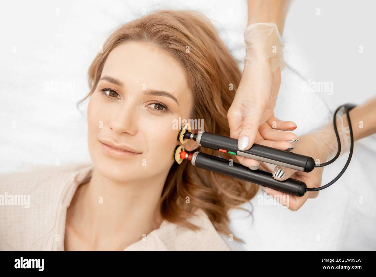 Young woman receiving RF lifting electric facial massage for face skin