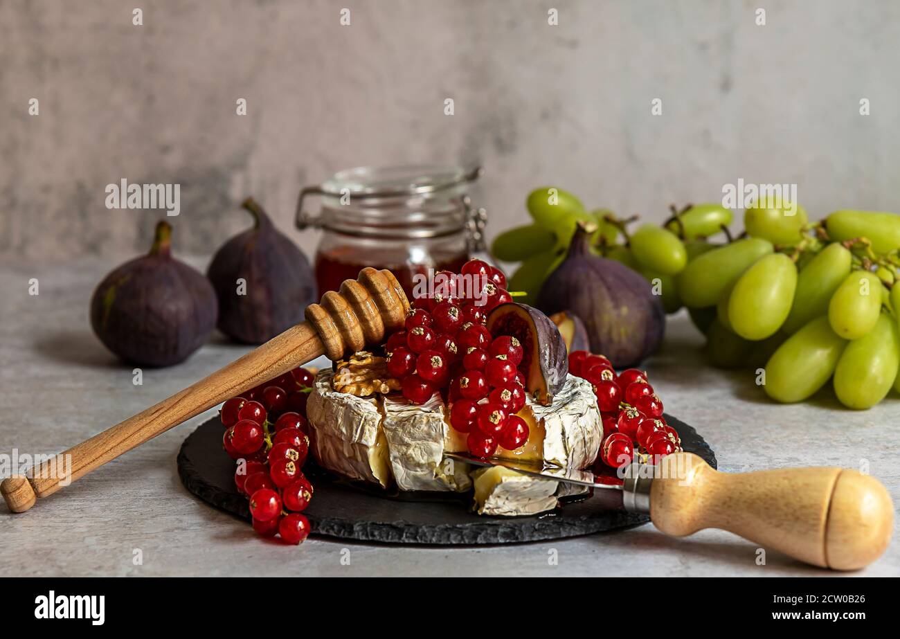 Oven baked Camembert with berries, honey, and figs Stock Photo Alamy