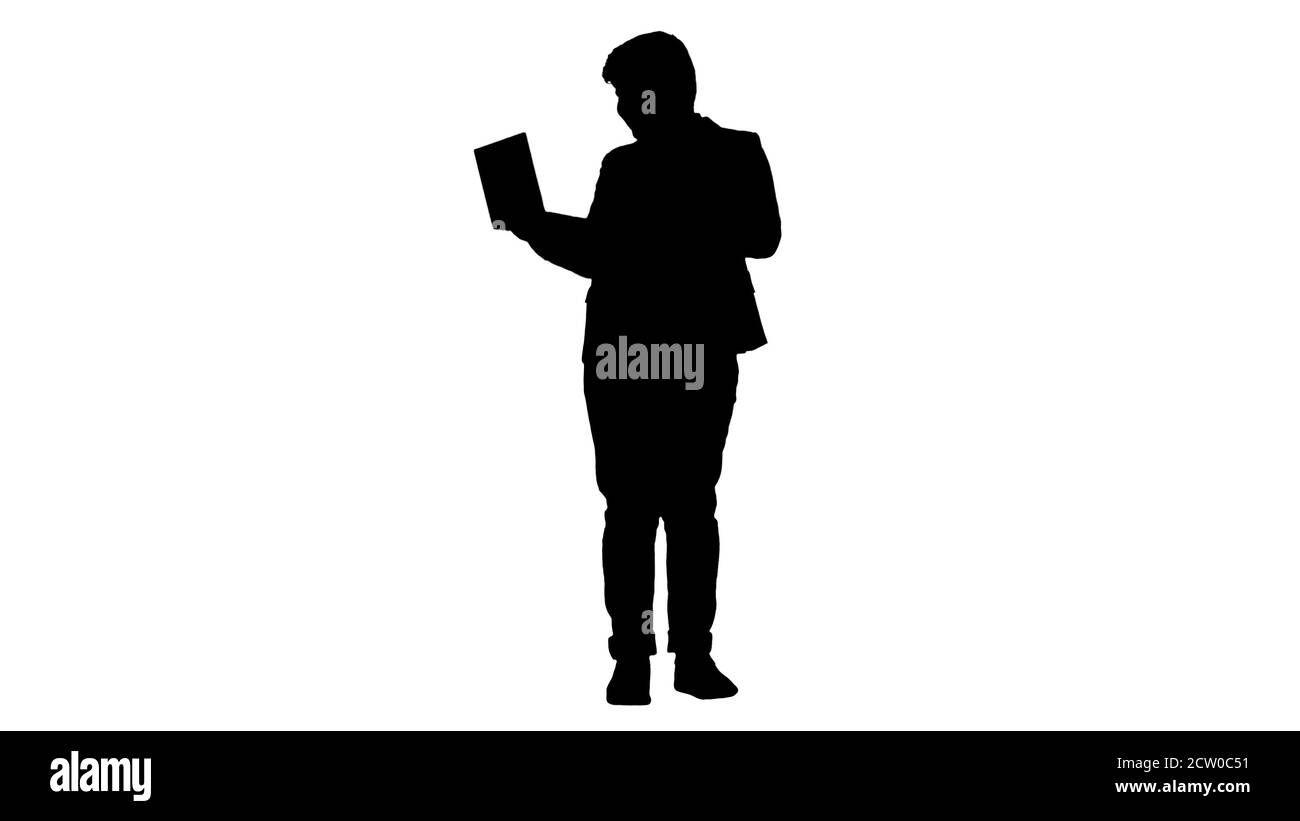 Silhouette Boy Standing Using Laptop And Making Win Gesture. Stock Photo