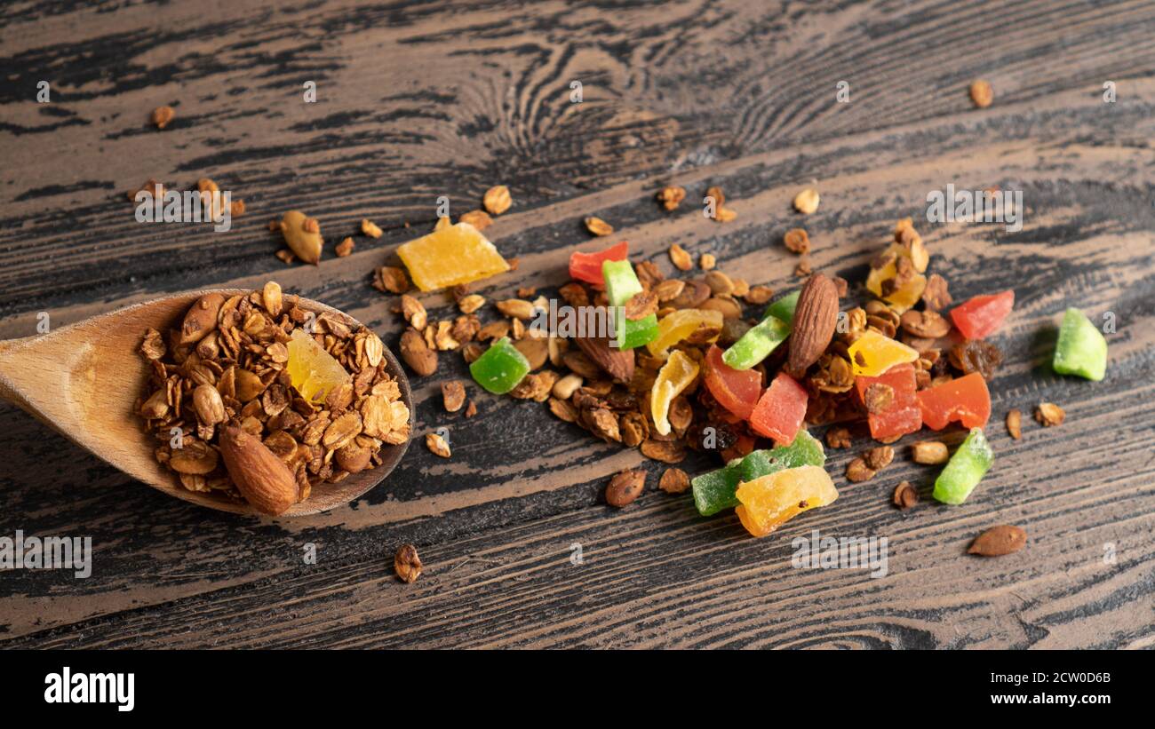 Spoon baked oatmeal with nuts and dried fruits. Advertising backdrop for granola. Homemade granola recipe Stock Photo