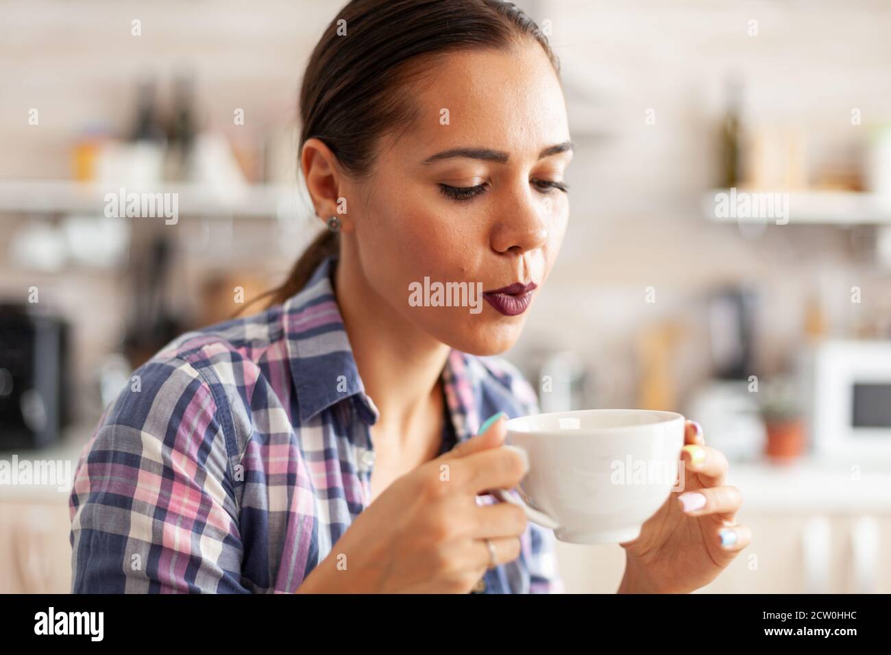 https://c8.alamy.com/comp/2CW0HHC/caucasian-young-woman-trying-to-drink-hot-green-tea-close-up-of-pretty-lady-sitting-in-the-kitchen-in-the-morning-during-breakfast-time-relaxing-with-tasty-natural-herbal-tea-from-white-teacup-2CW0HHC.jpg