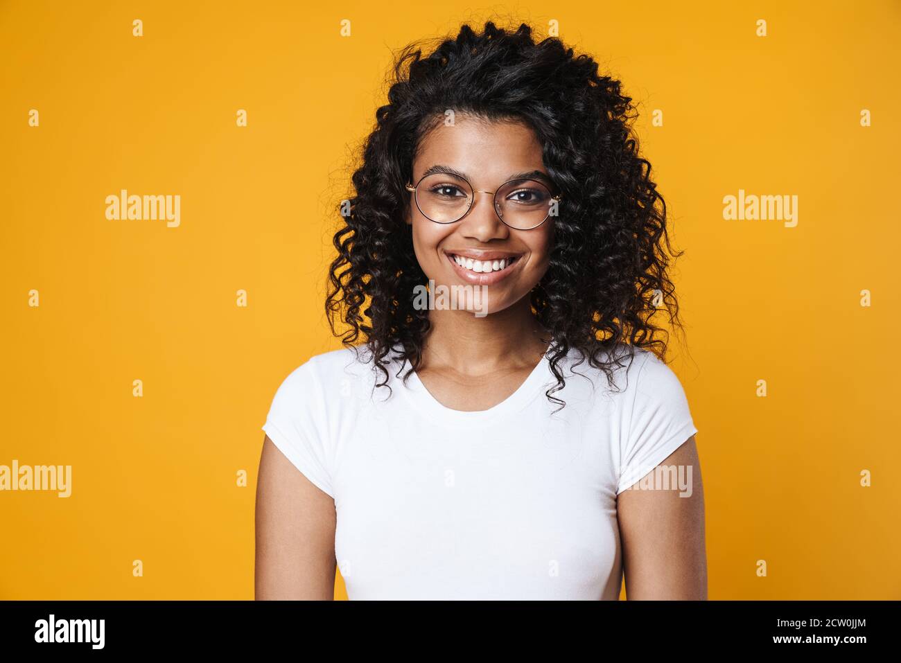 Image of happy african american girl in eyeglasses smiling at camera ...