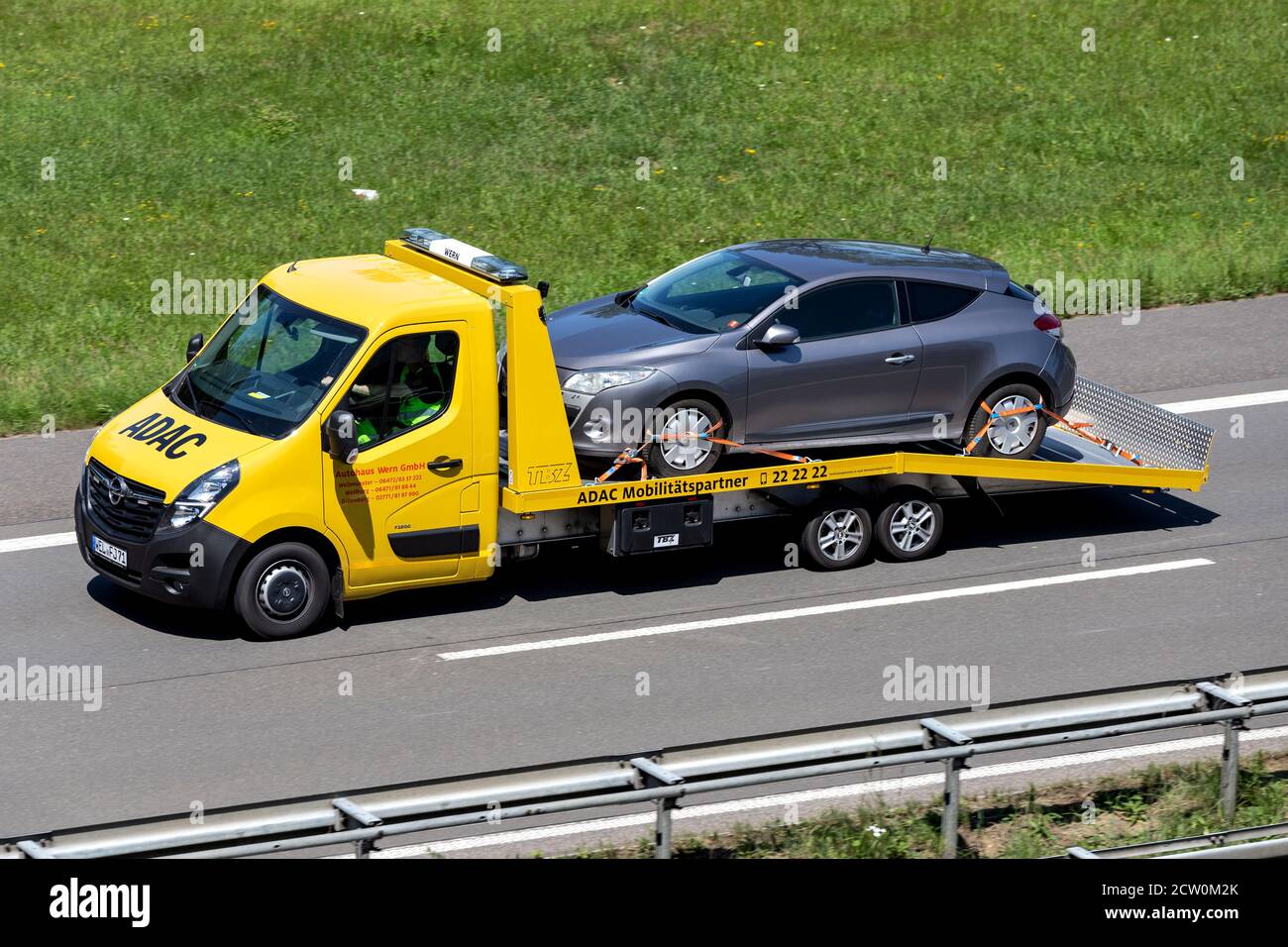 ADAC flatbed recovery vehicle on motorway. German ADAC it is the largest automobile club in Europe. Stock Photo