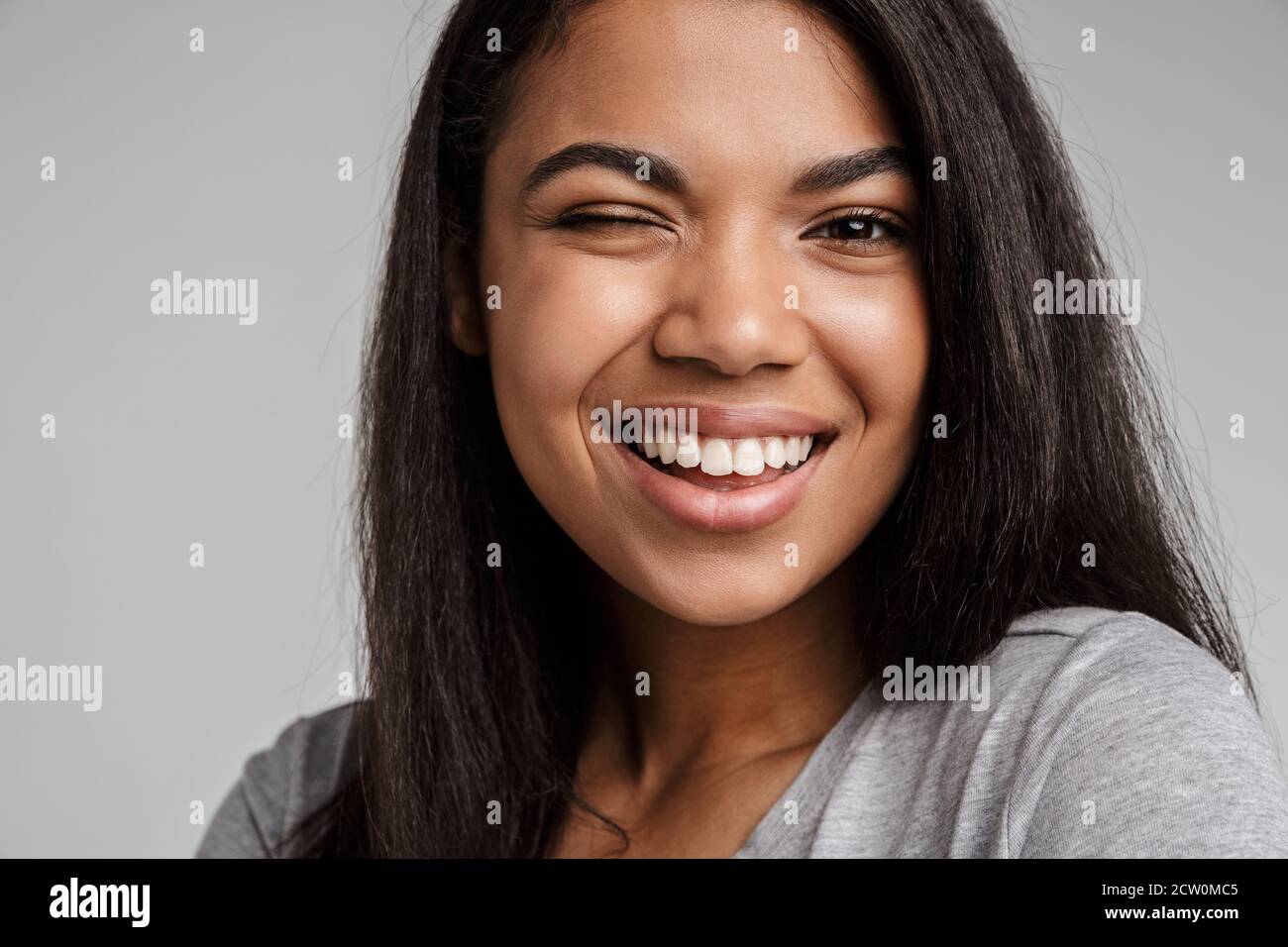 Portrait of a happy smiling young african woman with long dark hair ...