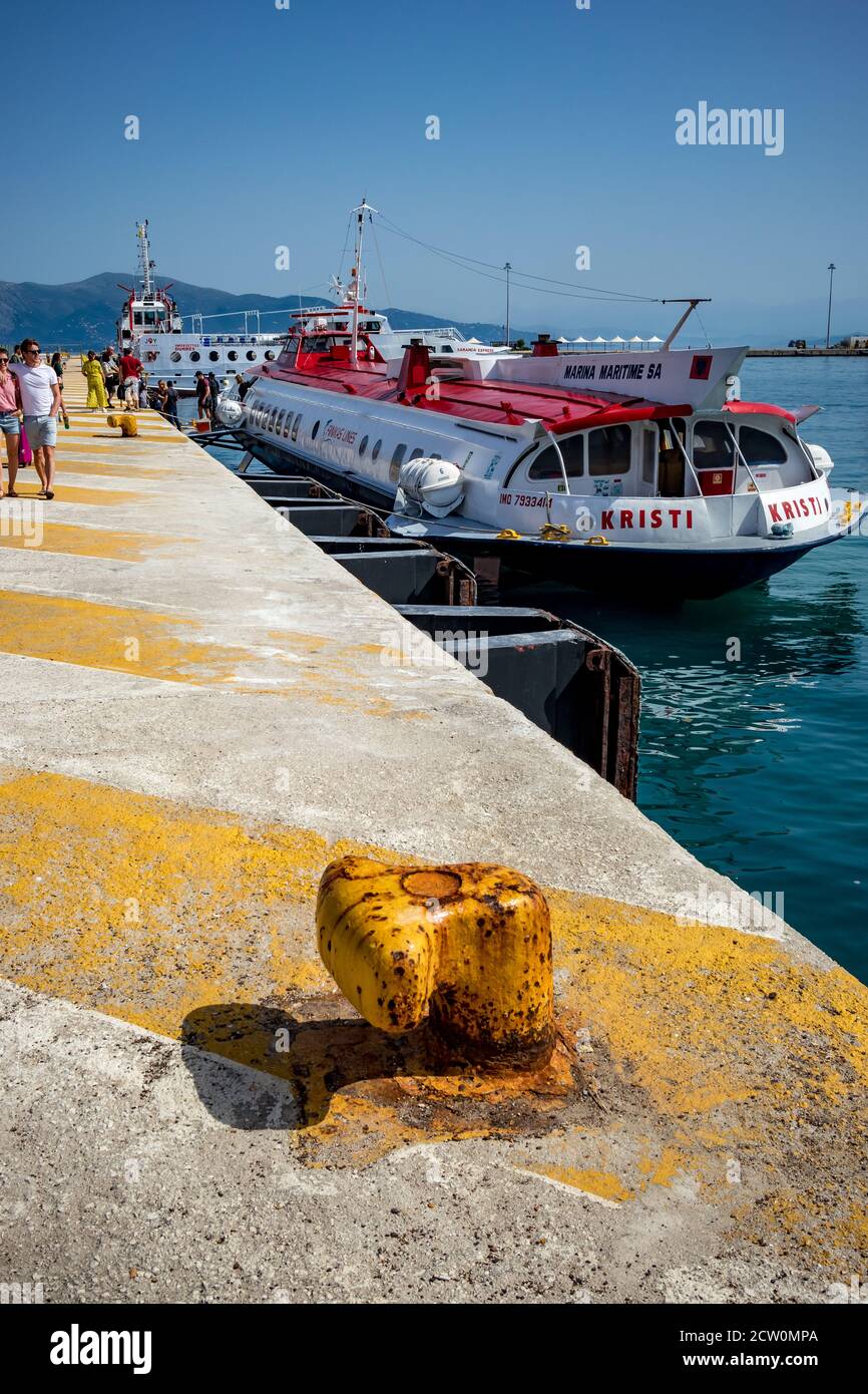 Corfu, Greece - July 20, 2019: Tourists get help getting out of the speed boat ferry coming from Saranda, Albania. Kerkira marina with the blue waters of Ionian Sea. Stock Photo