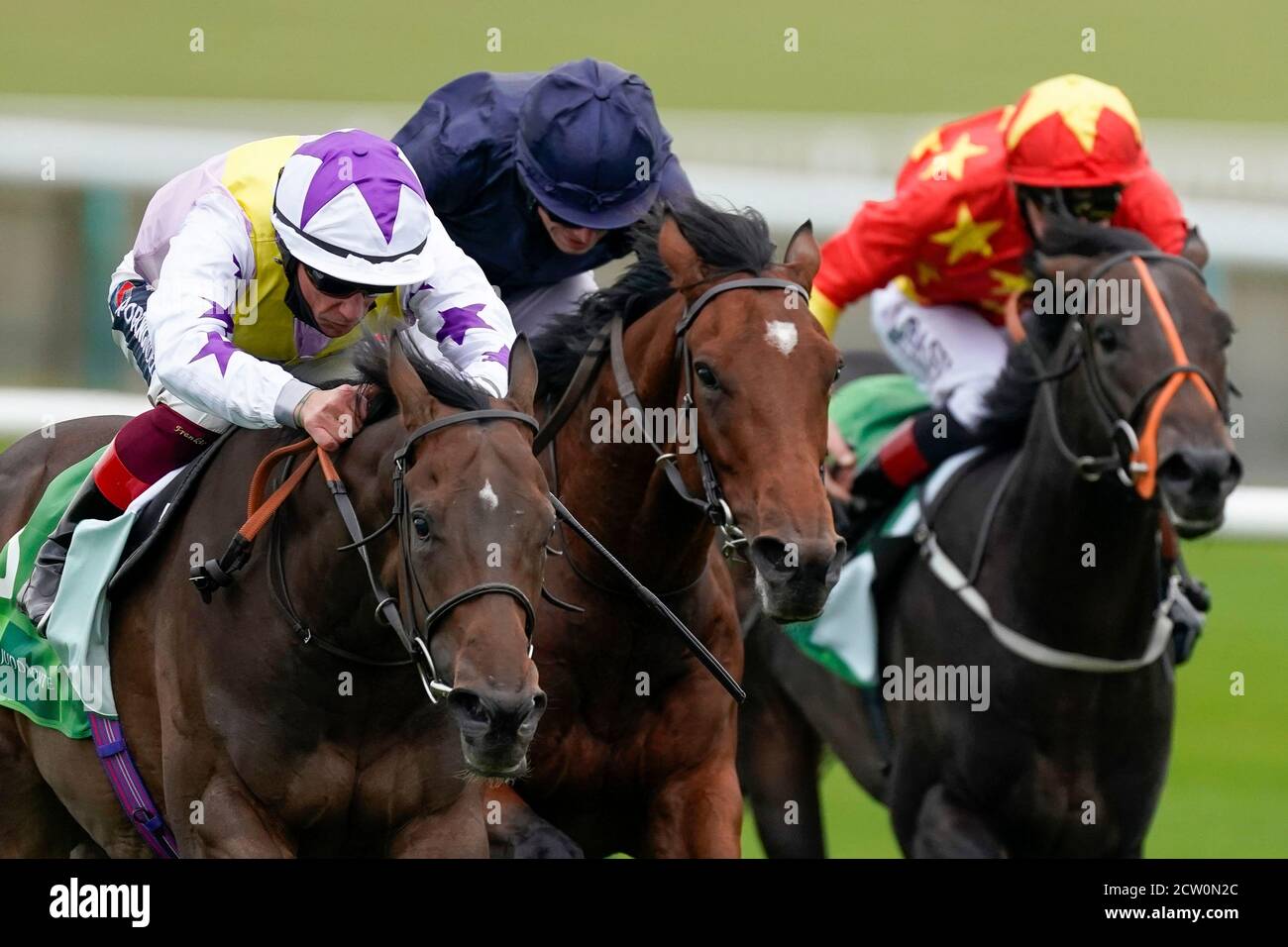 Frankie Dettori riding New Mandate (left) win The Juddmonte Royal Lodge Stakes from Ryan Moore and Ontario (centre) during day three of The Cambridgeshire Meeting at Newmarket Racecourse. Stock Photo