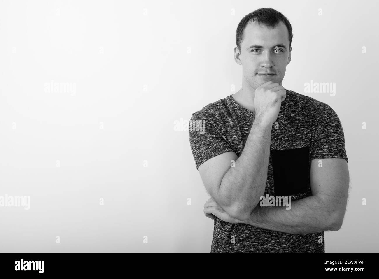 Studio shot of young muscular man thinking against white background ...