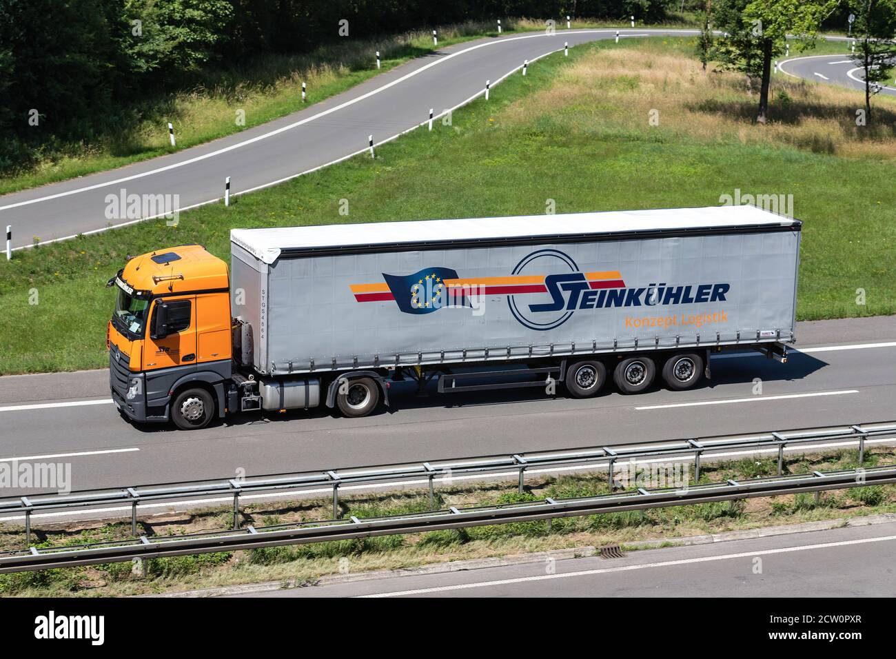Steinkühler Mercedes-Benz Actros truck with curtainside trailer on motorway. Stock Photo